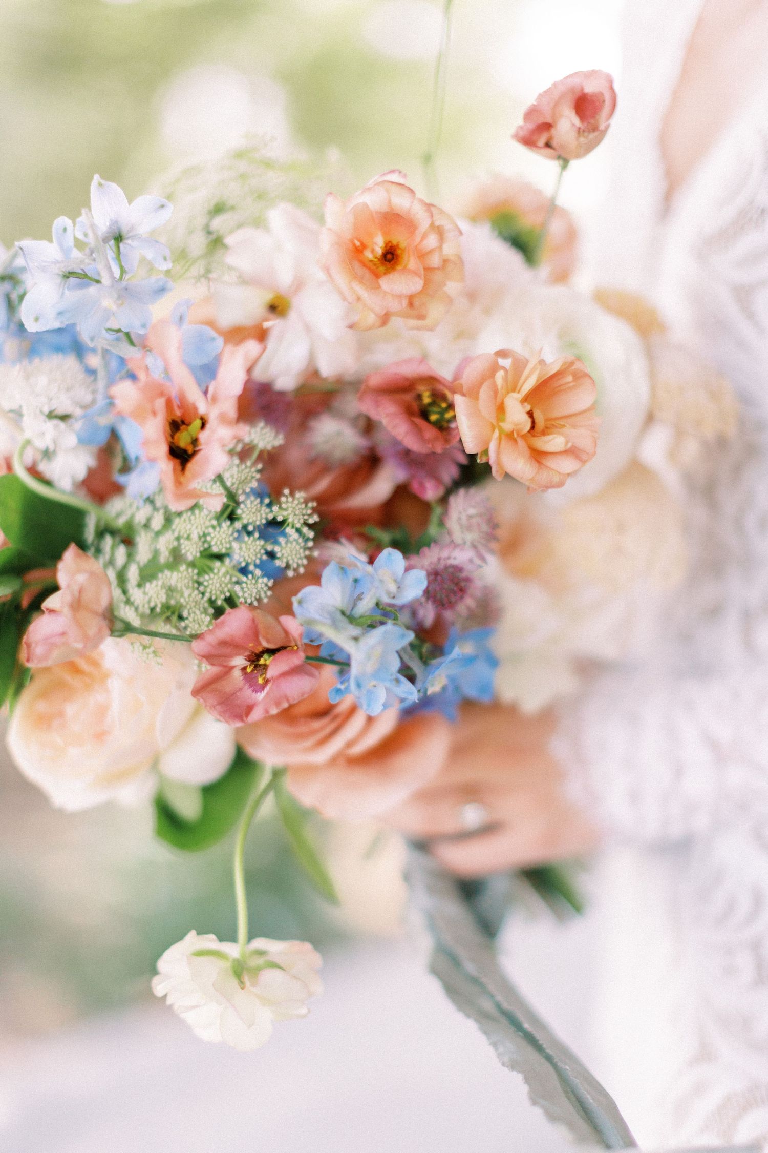 Dreamy pastel floral arrangement featuring peach and blue blooms in soft focus.