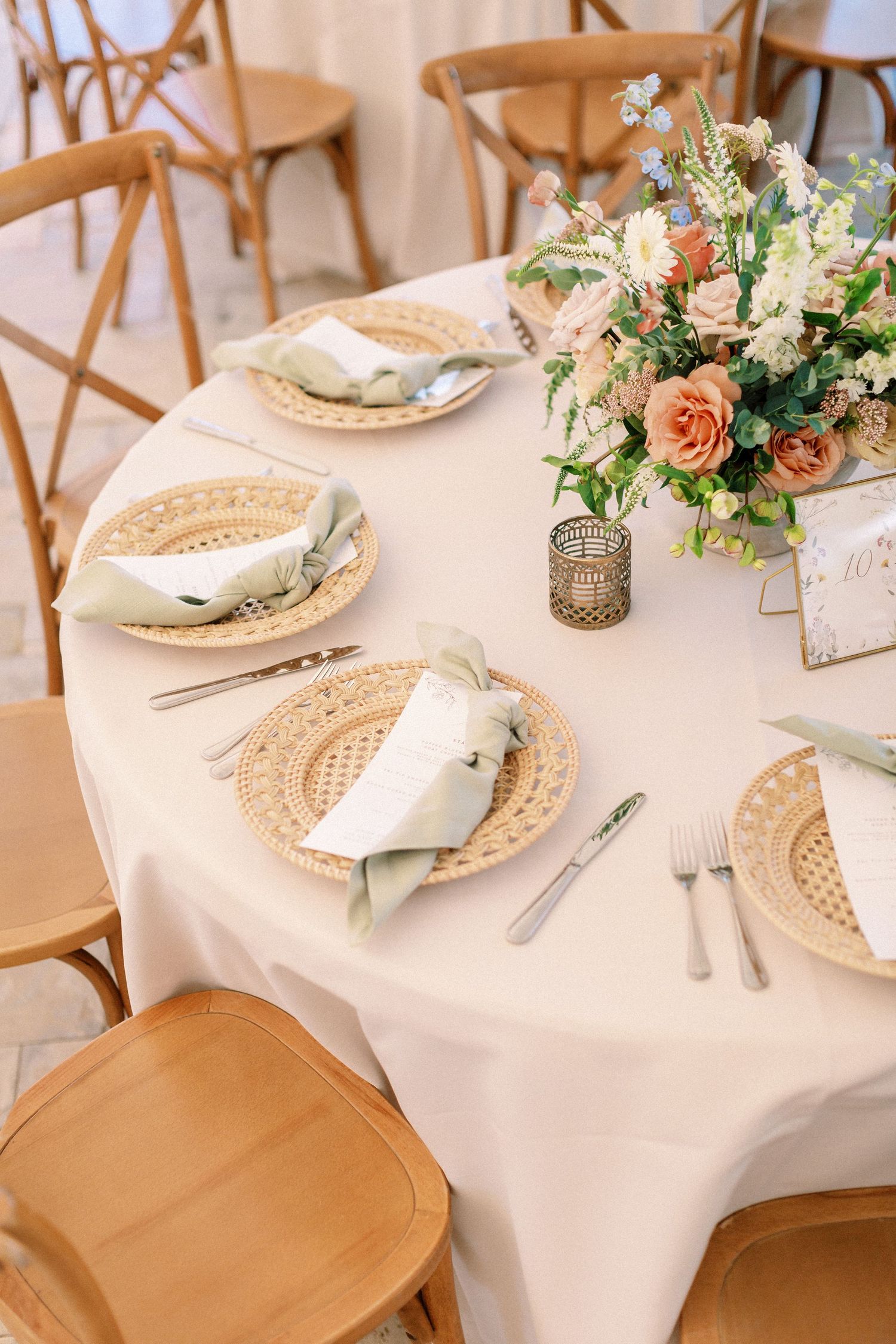 Elegant wedding reception table settings with white linens and woven charger plates.