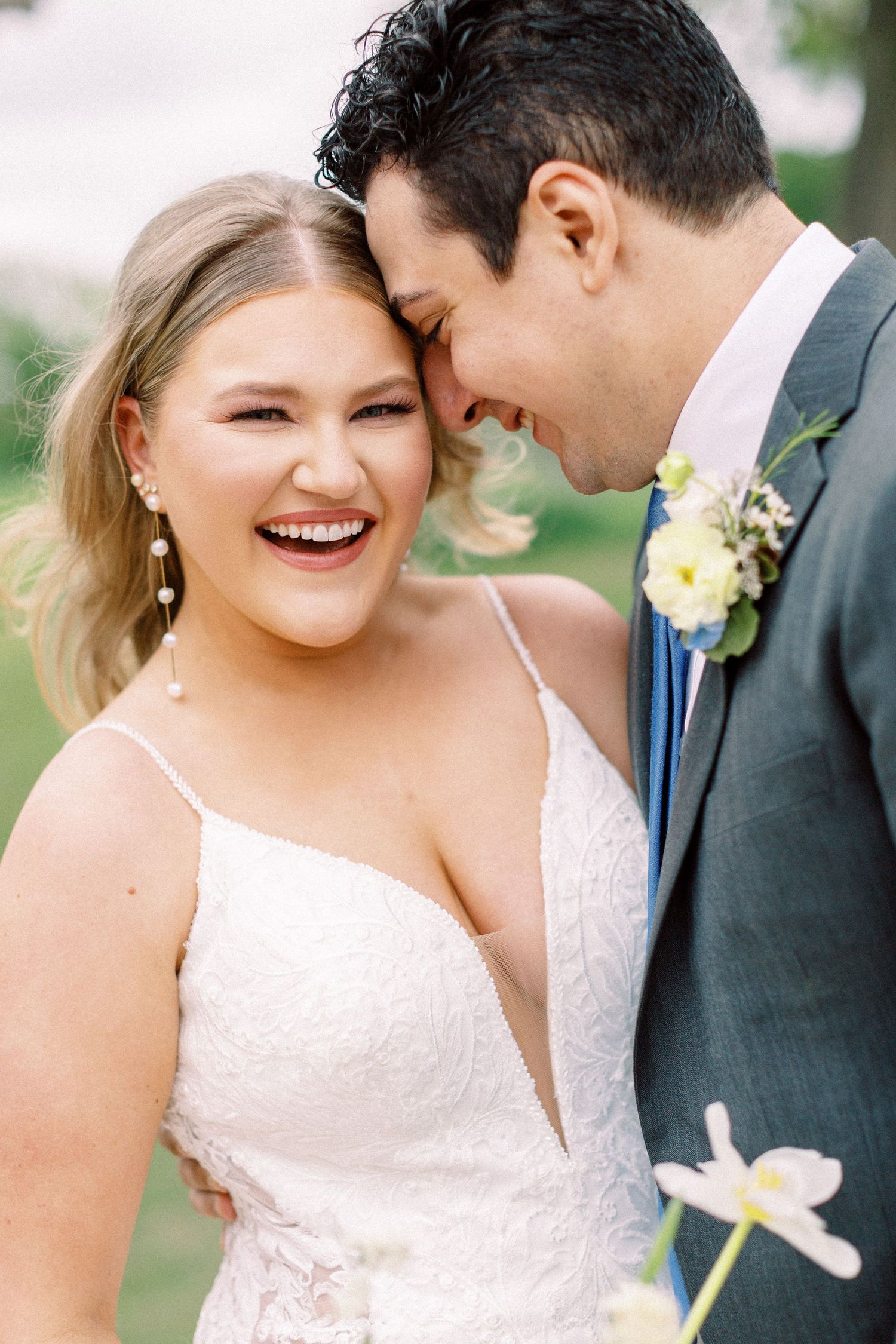 A joyful wedding couple shares an intimate moment outdoors.