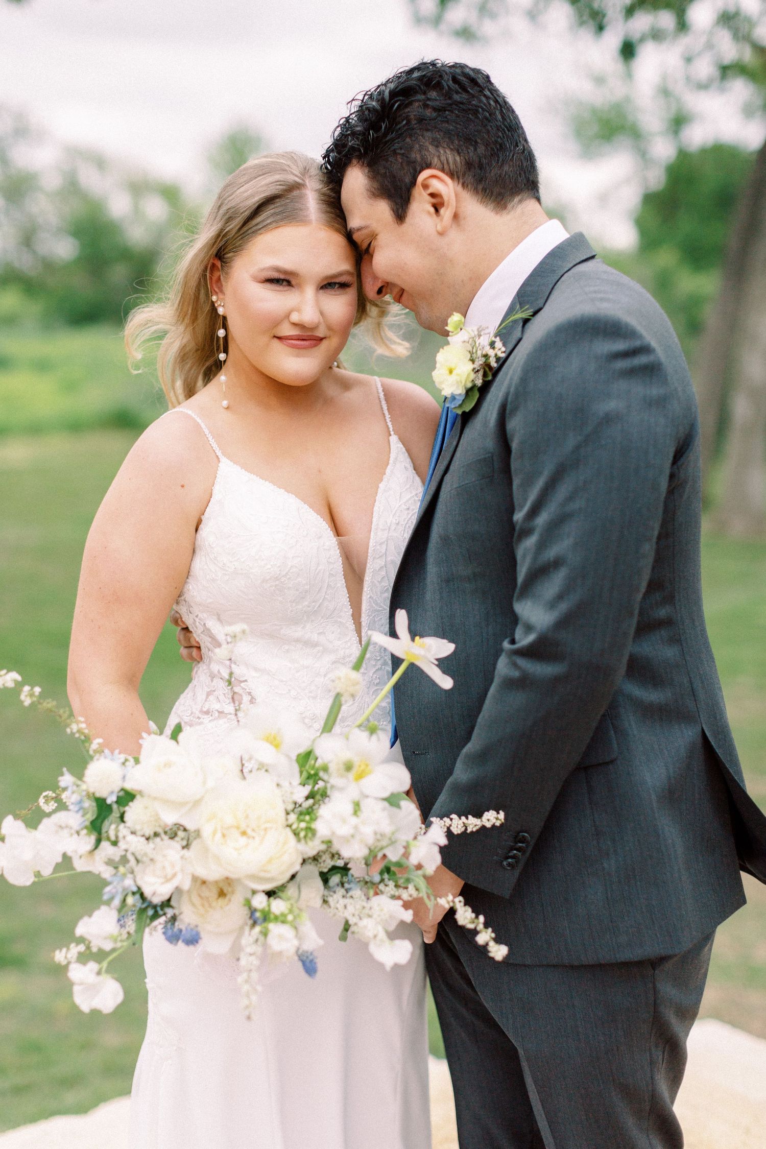 A romantic wedding portrait of a couple with a delicate spring bouquet.