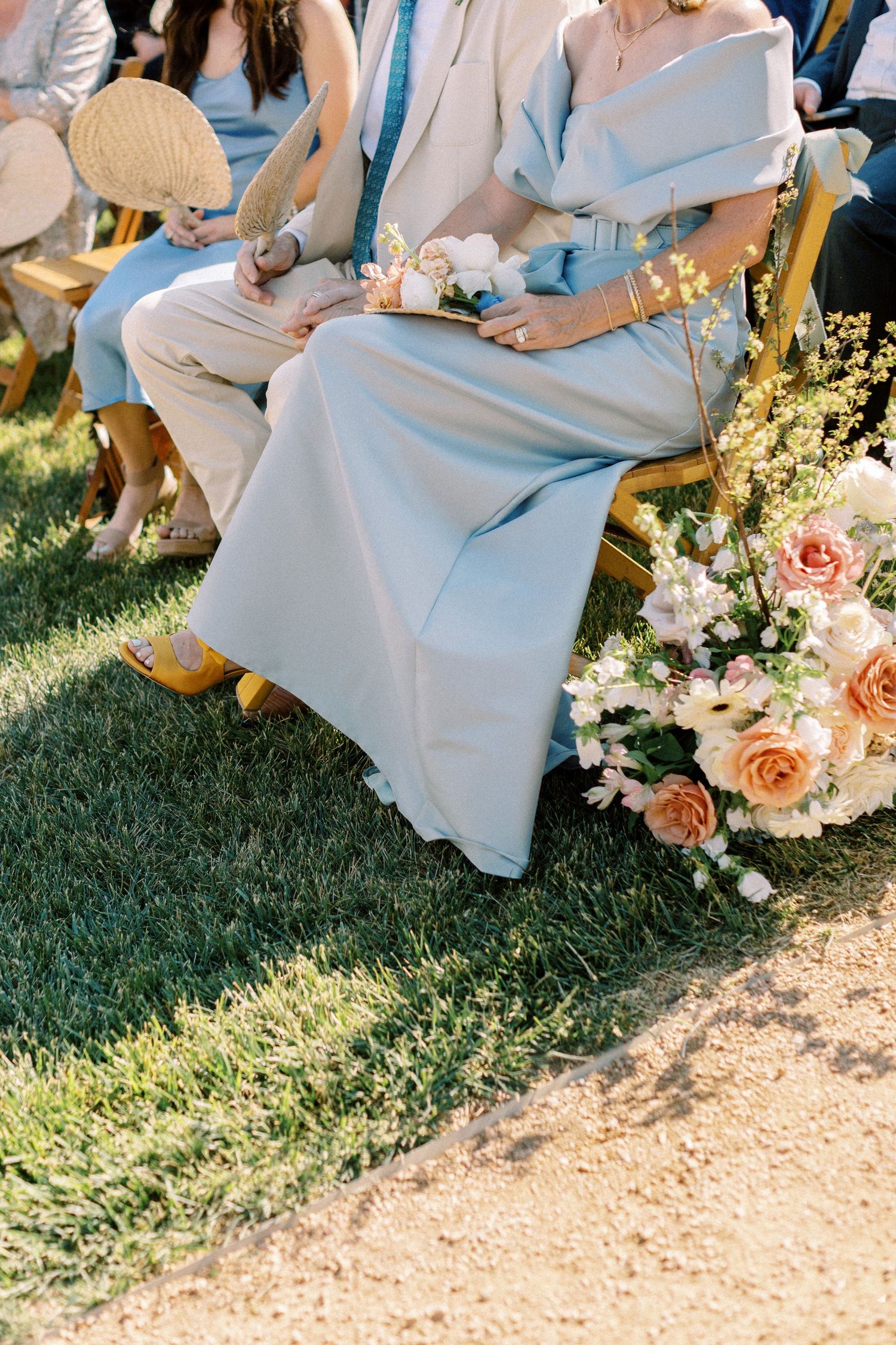 Wedding guest during ceremony near Marfa, Texas wearing yellow heels and a baby blue dress