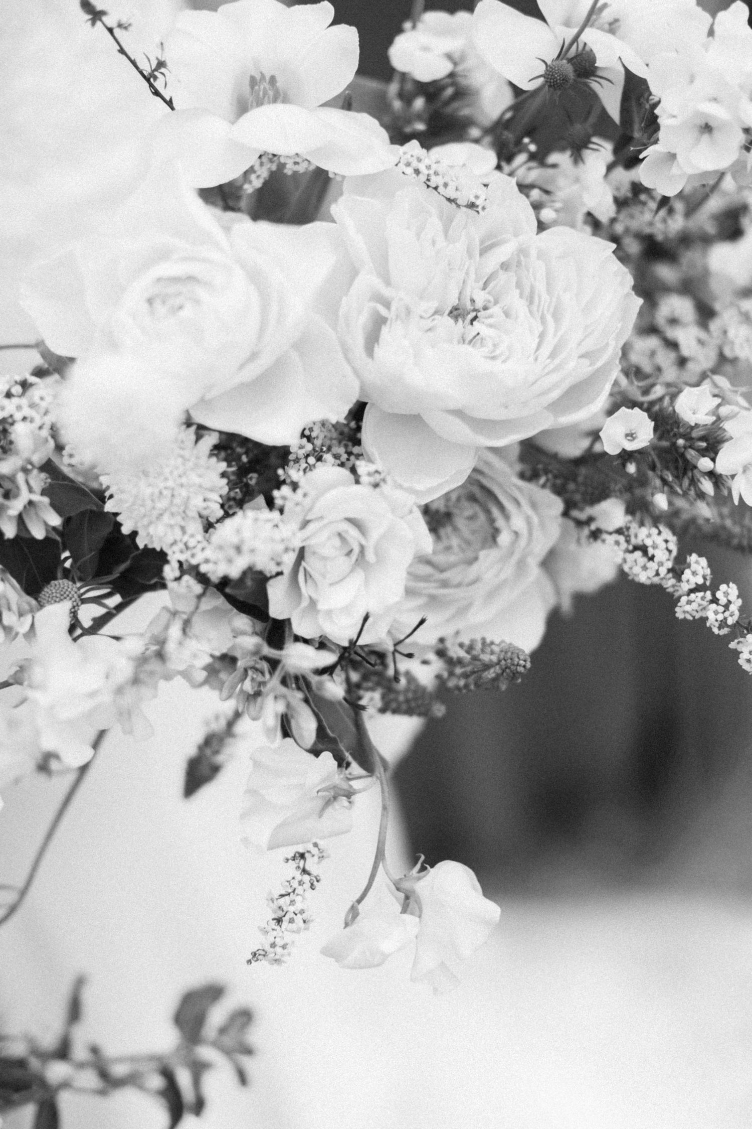 Close-up of white roses and delicate flowers in a wedding arrangement.