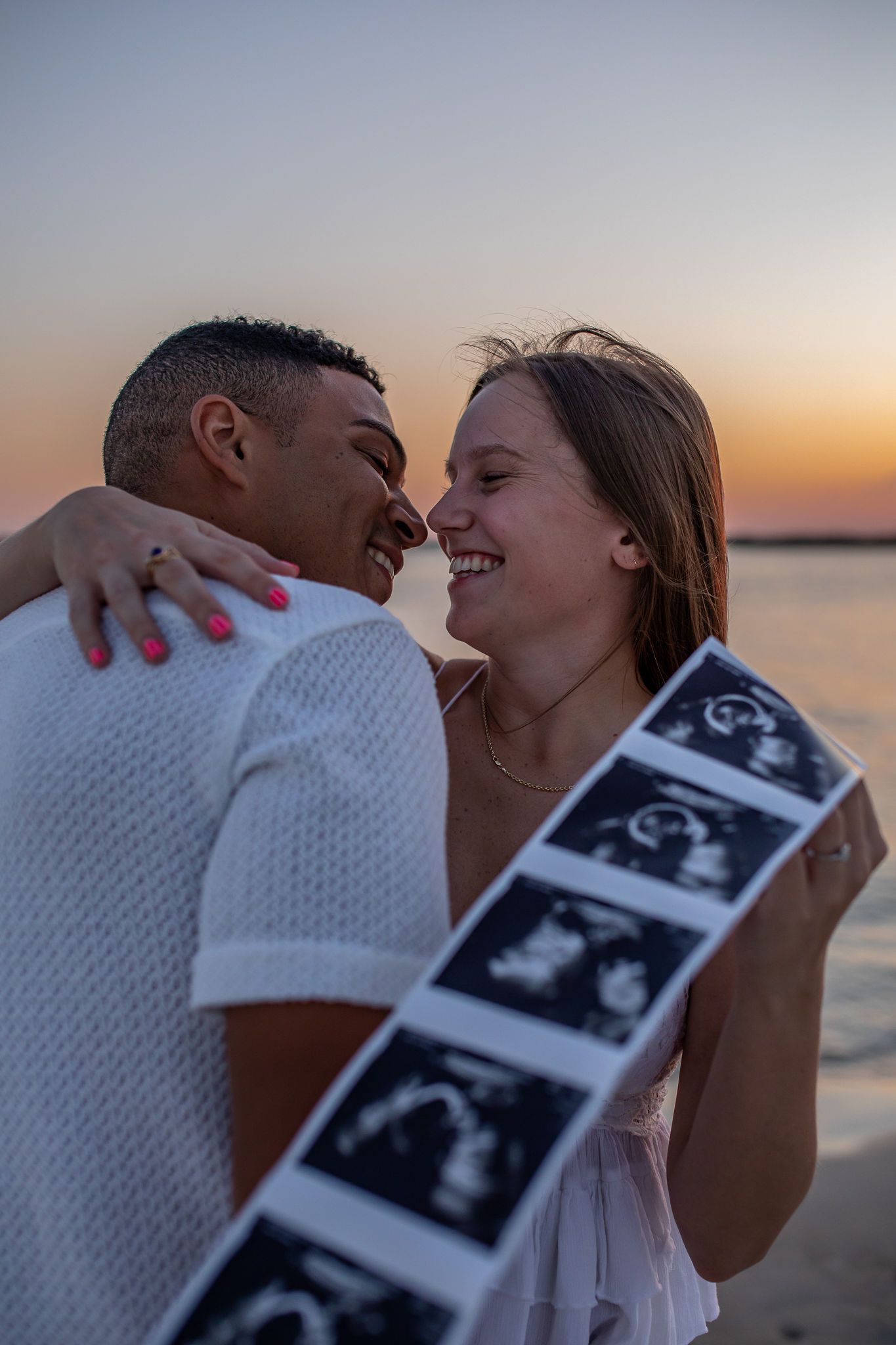 Intimate couple moment at sunset beach with ultrasound strip.