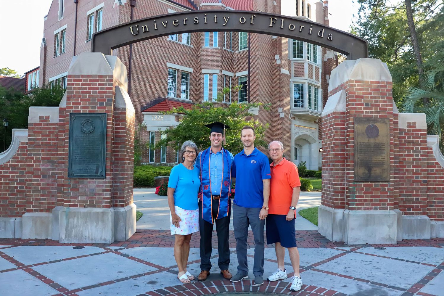Wide angle shot of people gathered in front of a stately brick educational building.