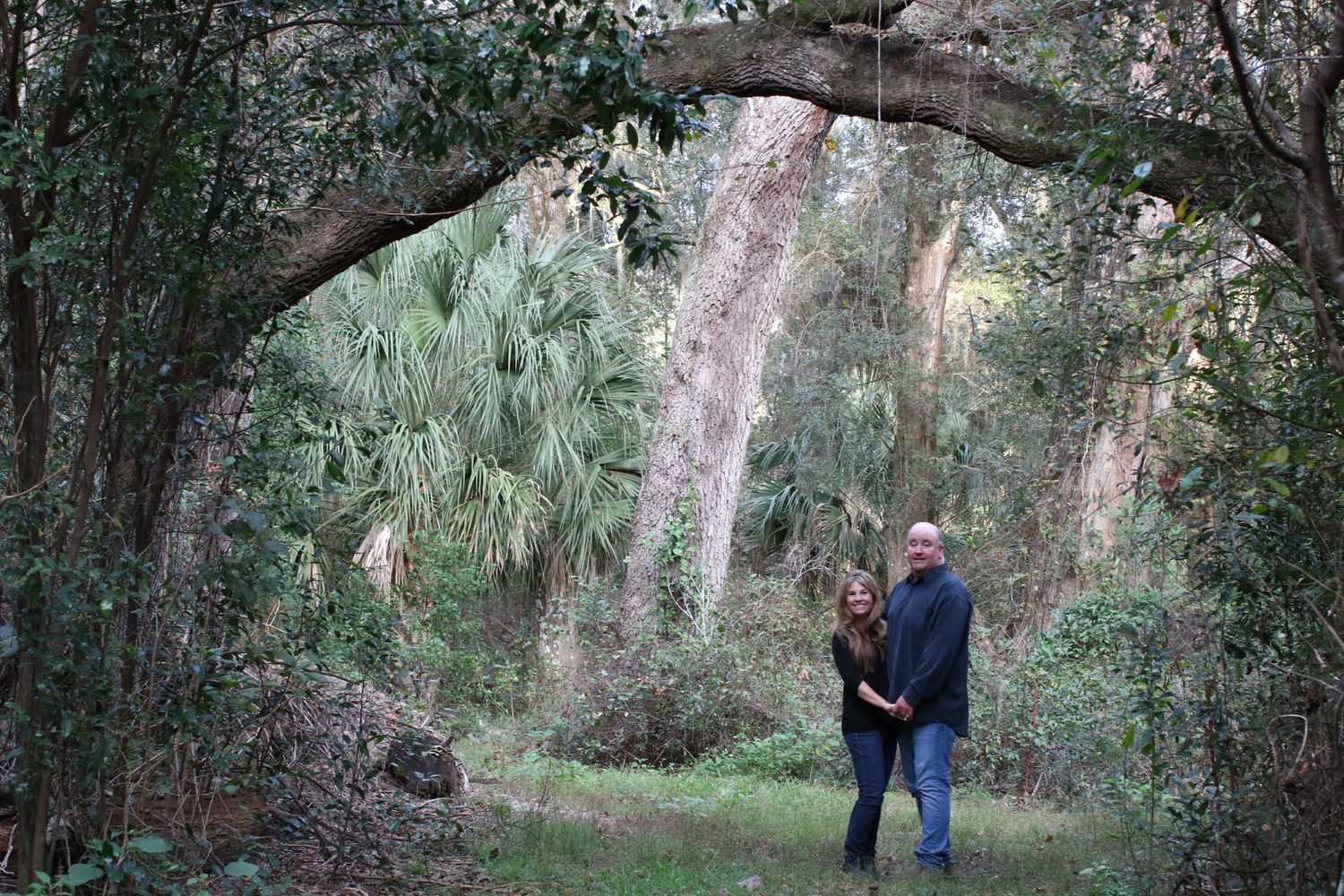 Natural outdoor engagement photography session in a wooded area with Spanish moss.
