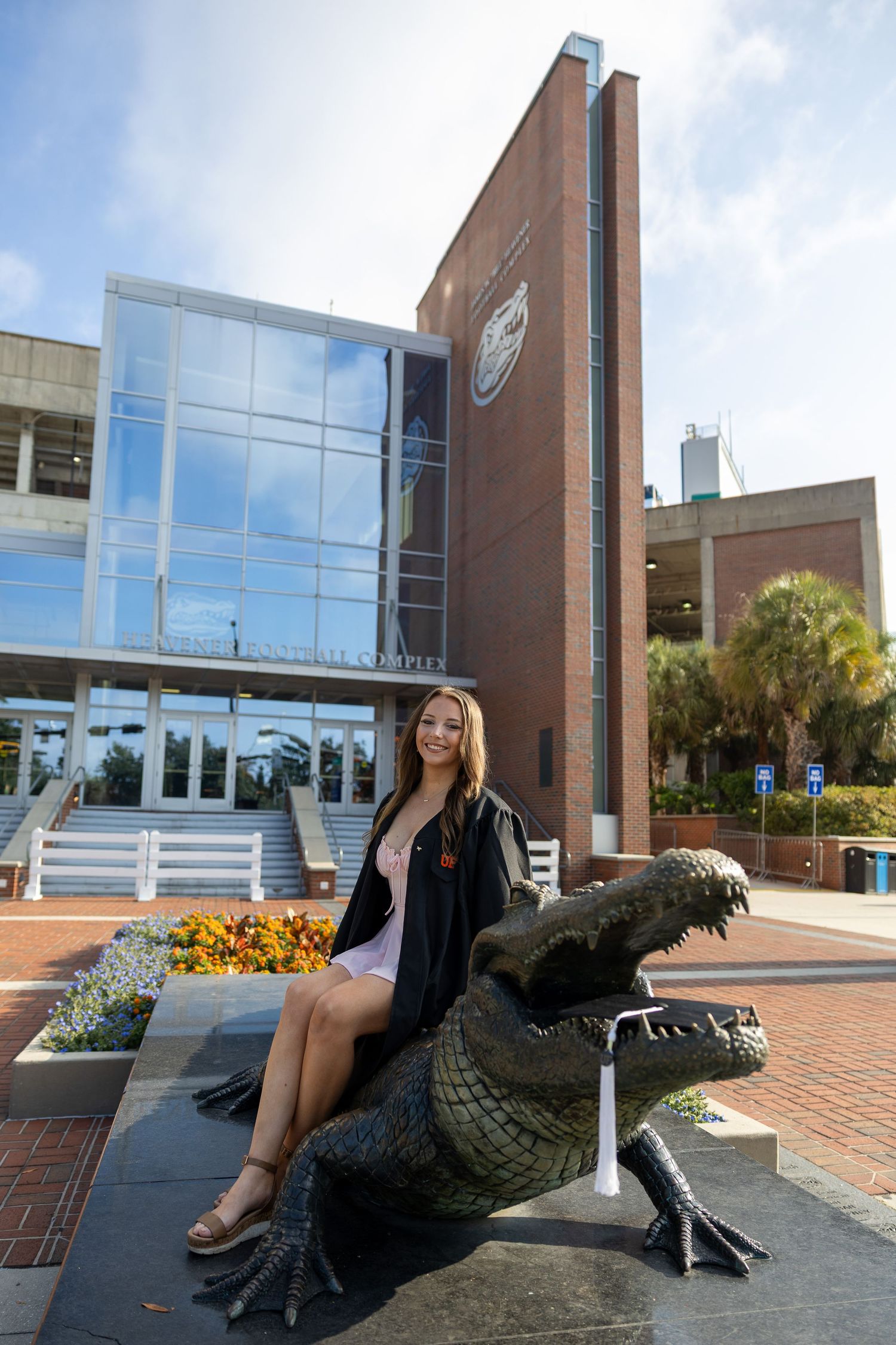 A decorative alligator statue sits outside a modern brick building.
