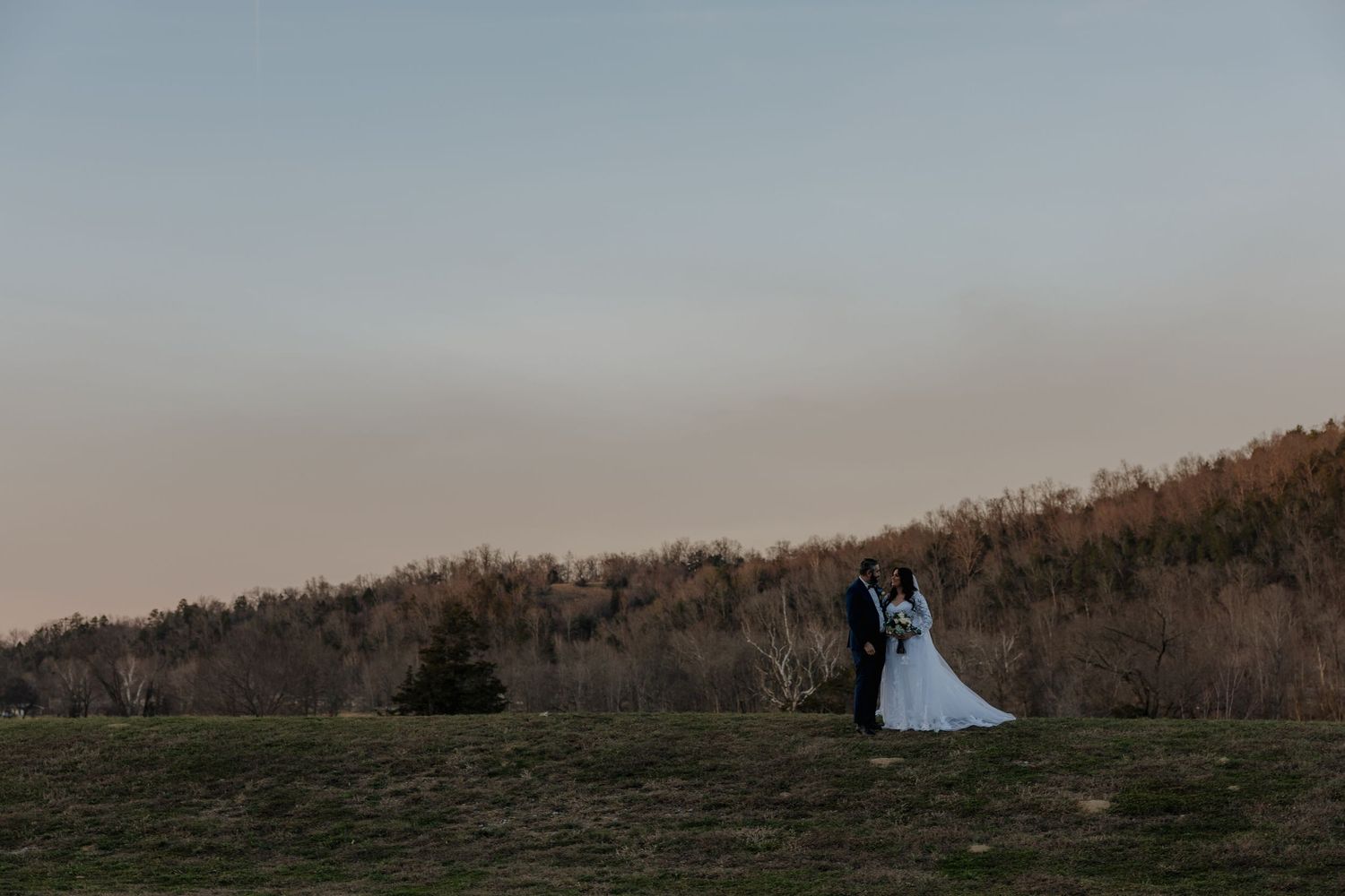 Panoramic view of a rustic wooden fence stretching across rolling hills during golden hour.