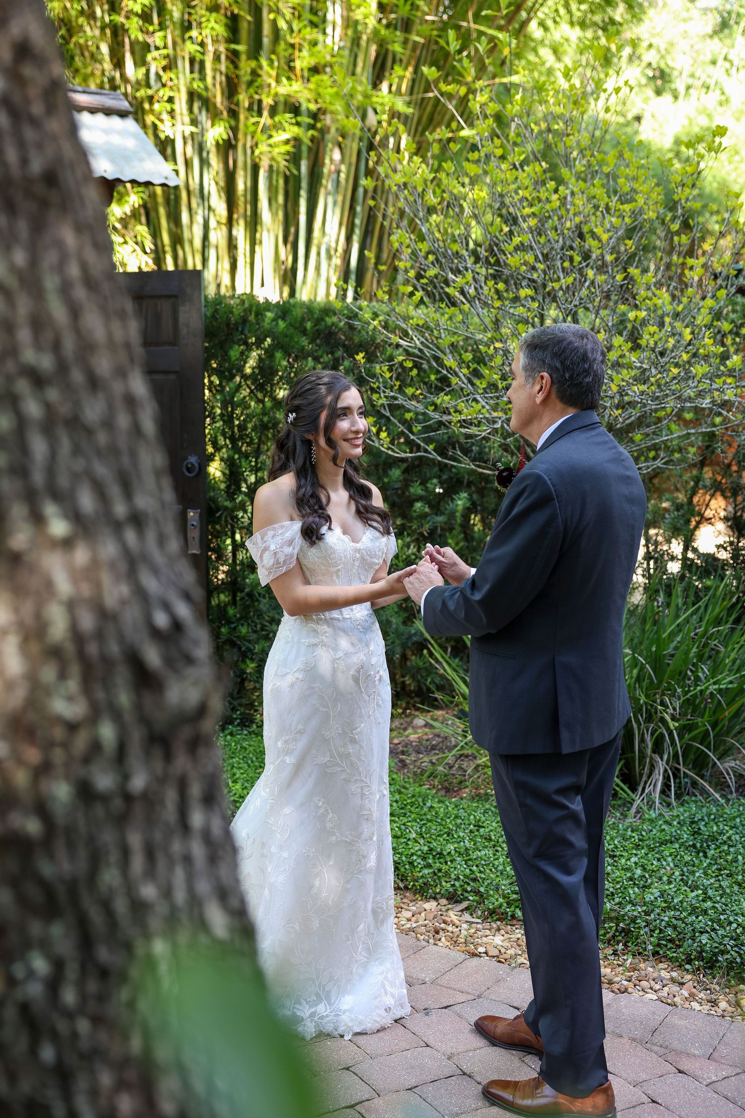 Intimate garden ceremony moment under lush greenery and trees.