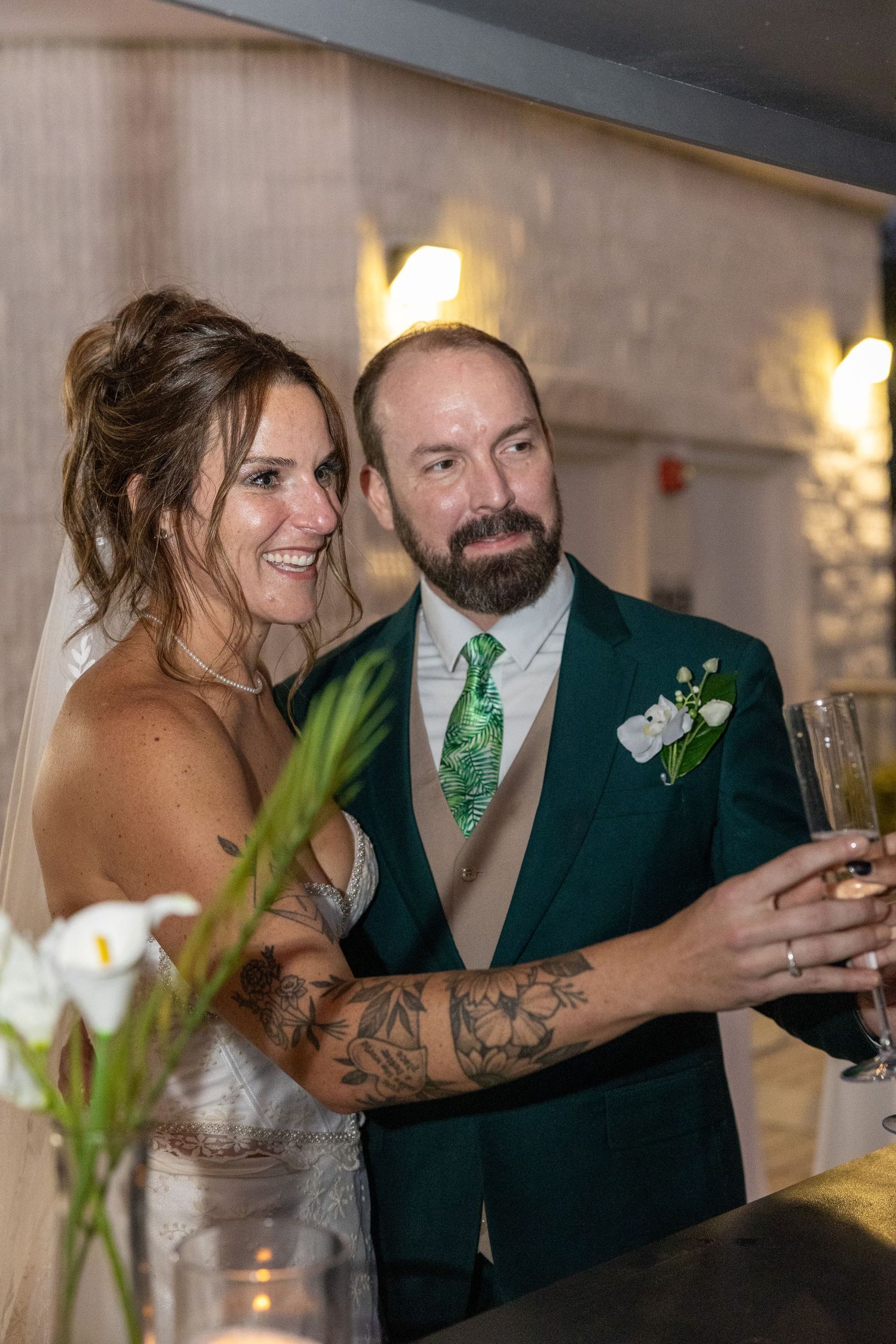 Indoor reception scene with elegant table settings and floral decorations.