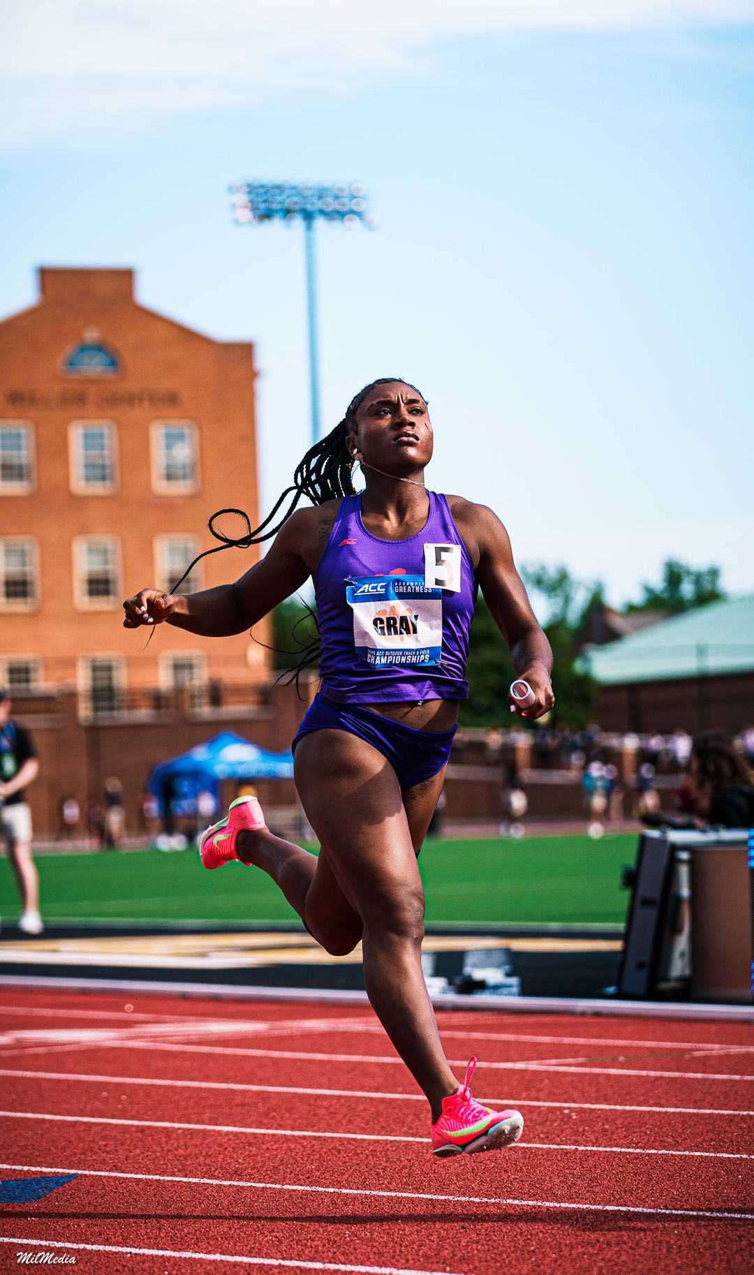 Athletic competitors lean forward in dramatic finish line dives on a red running track during the ACC Track and Field Championships.