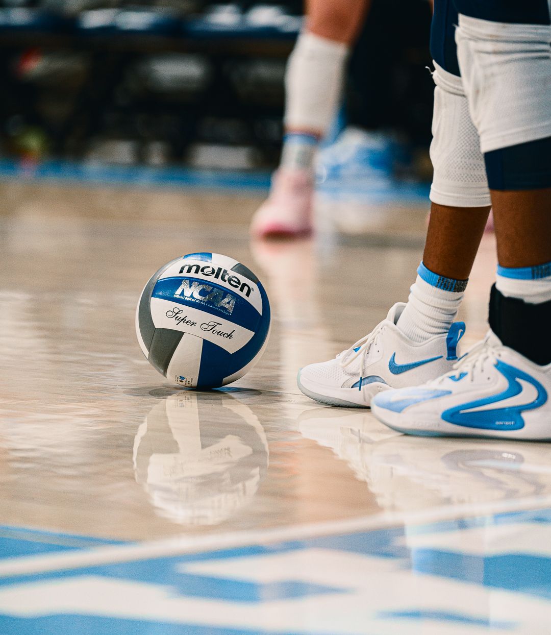 Close-up of volleyball players' feet and shoes on the court during a game.