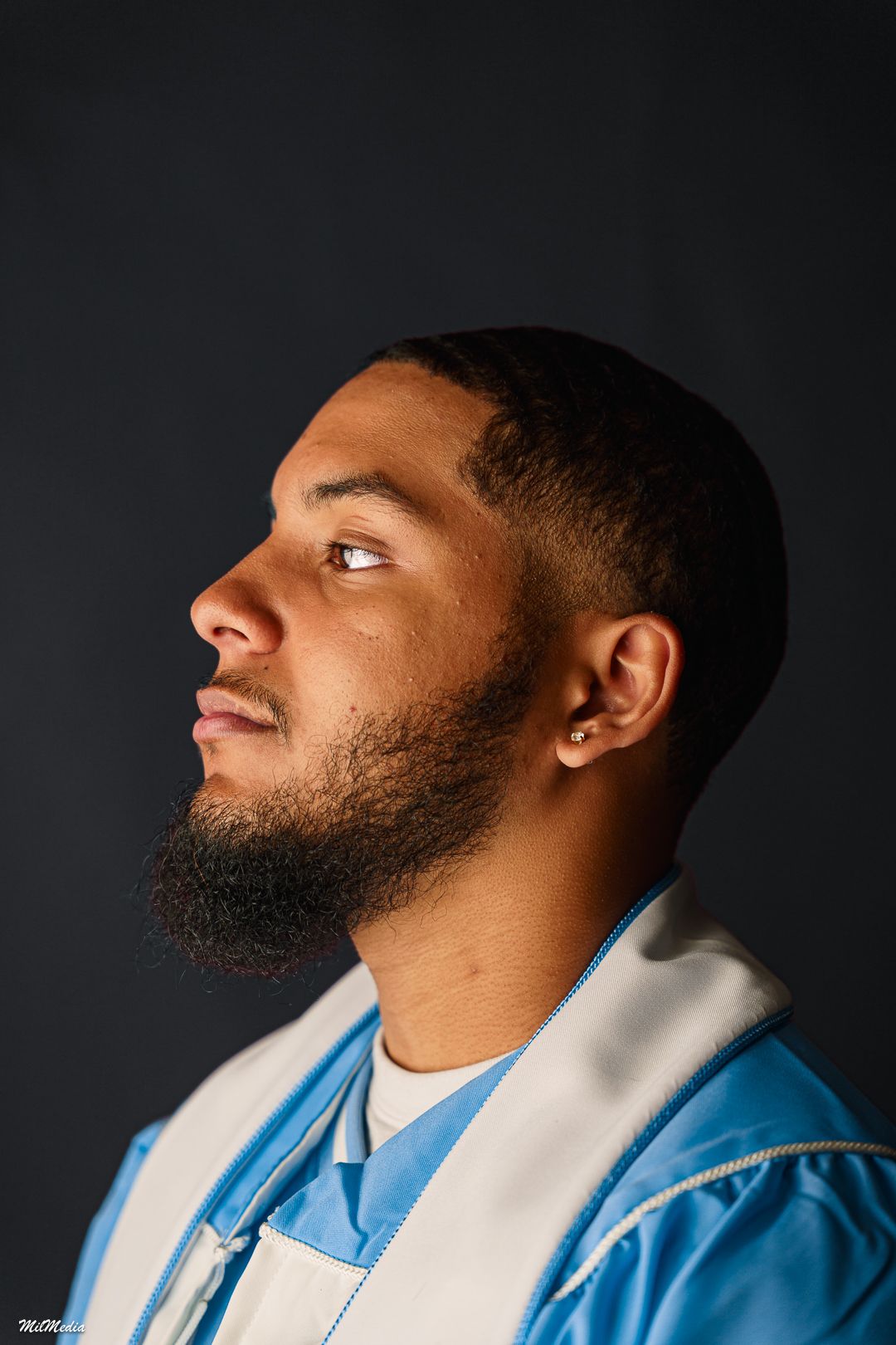Profile shots of a graduate in light blue cap and gown against a dark background.