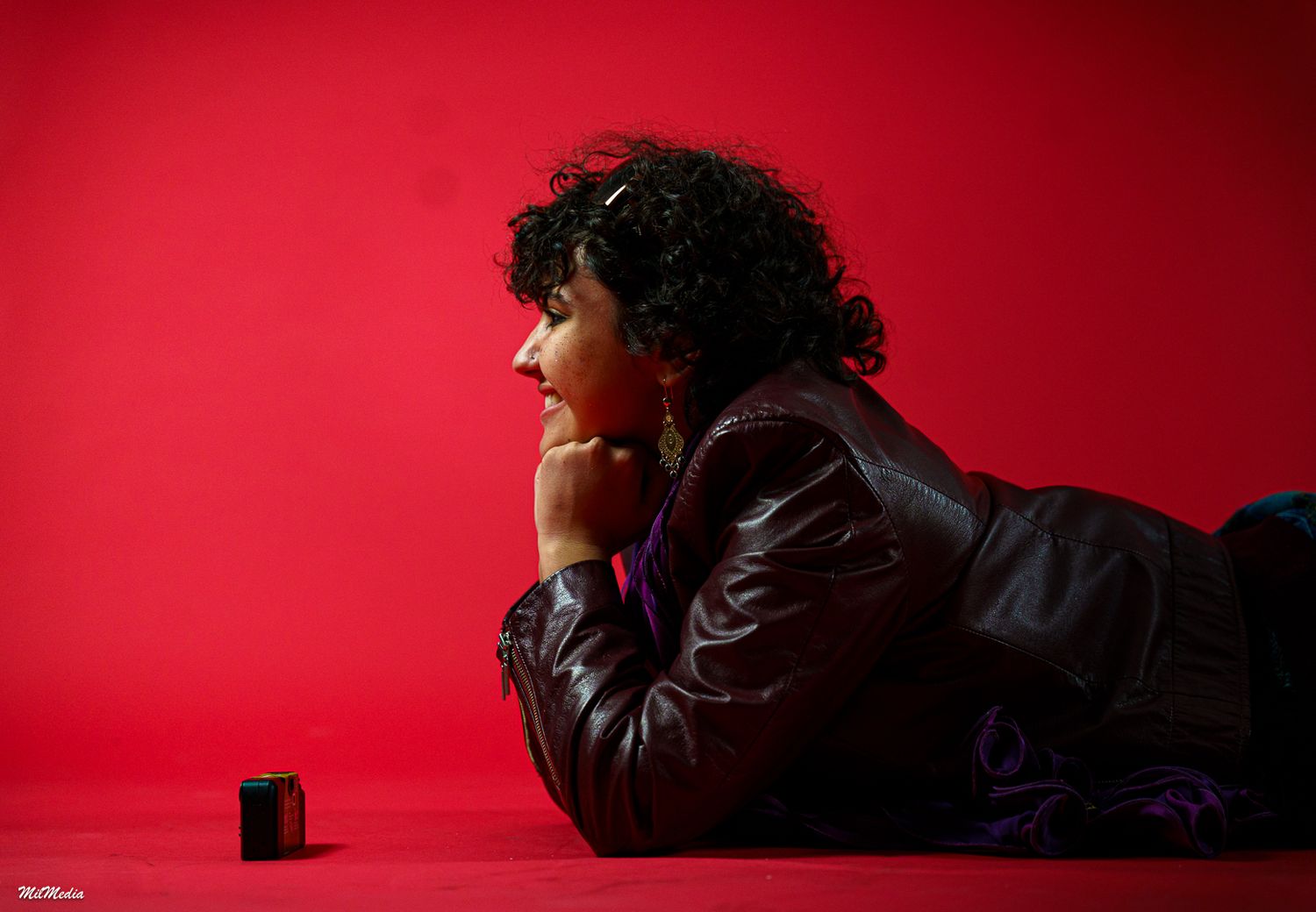 Artistic portrait series with dramatic lighting against deep red background.