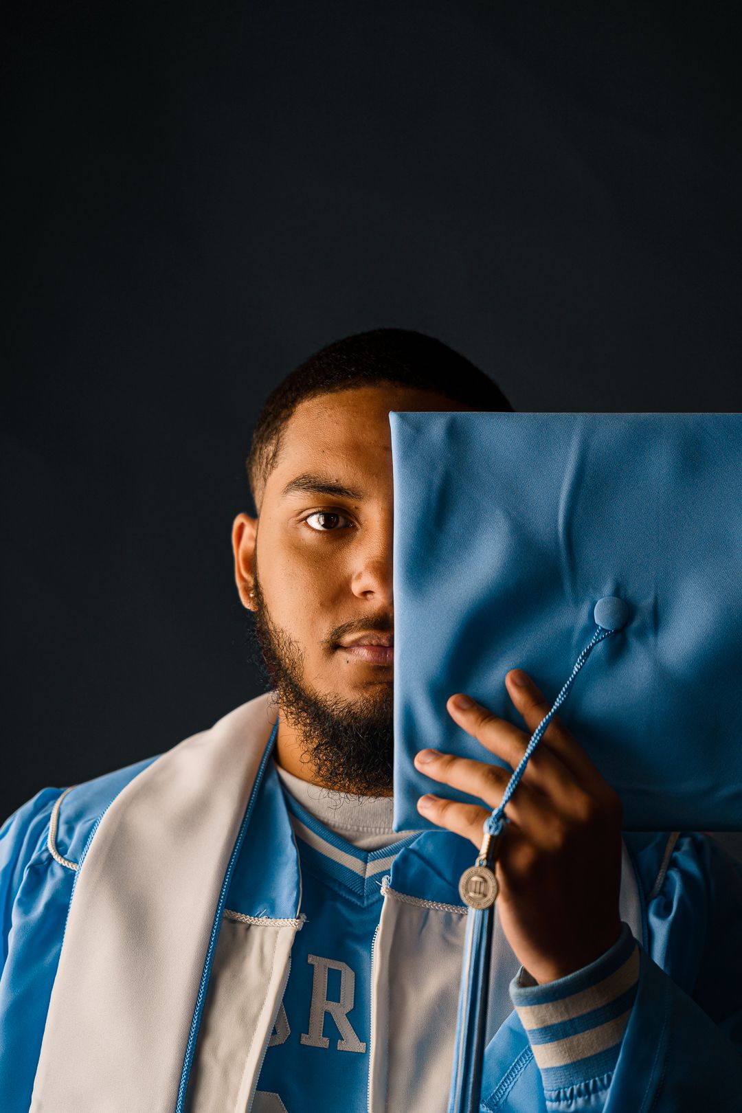Creative portrait series showing fragments of person against dark background with blue accent.