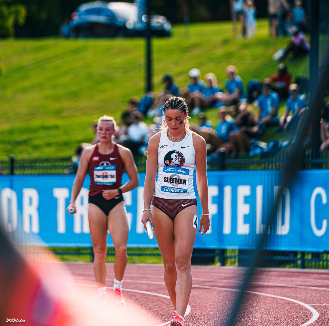Athletes compete in sprint race on outdoor track with spectators visible in background during the ACC Track and Field Championships.