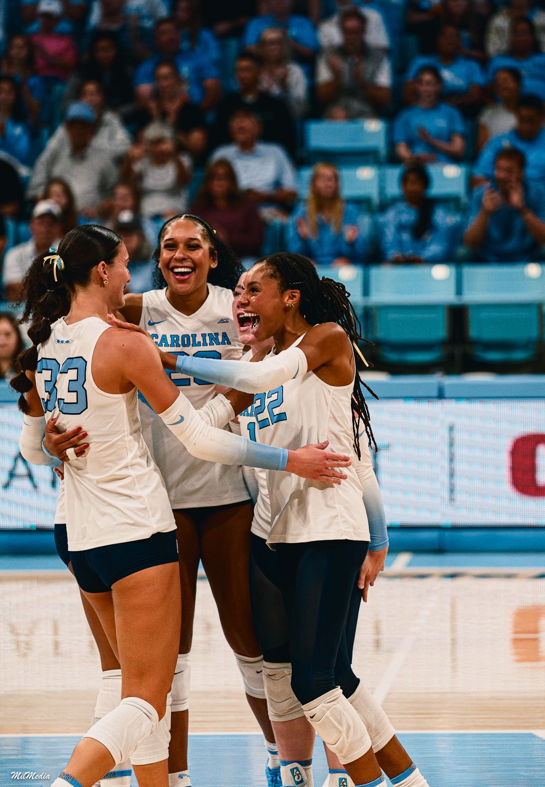 UNC volleyball team celebrates together during match with energetic group celebration.