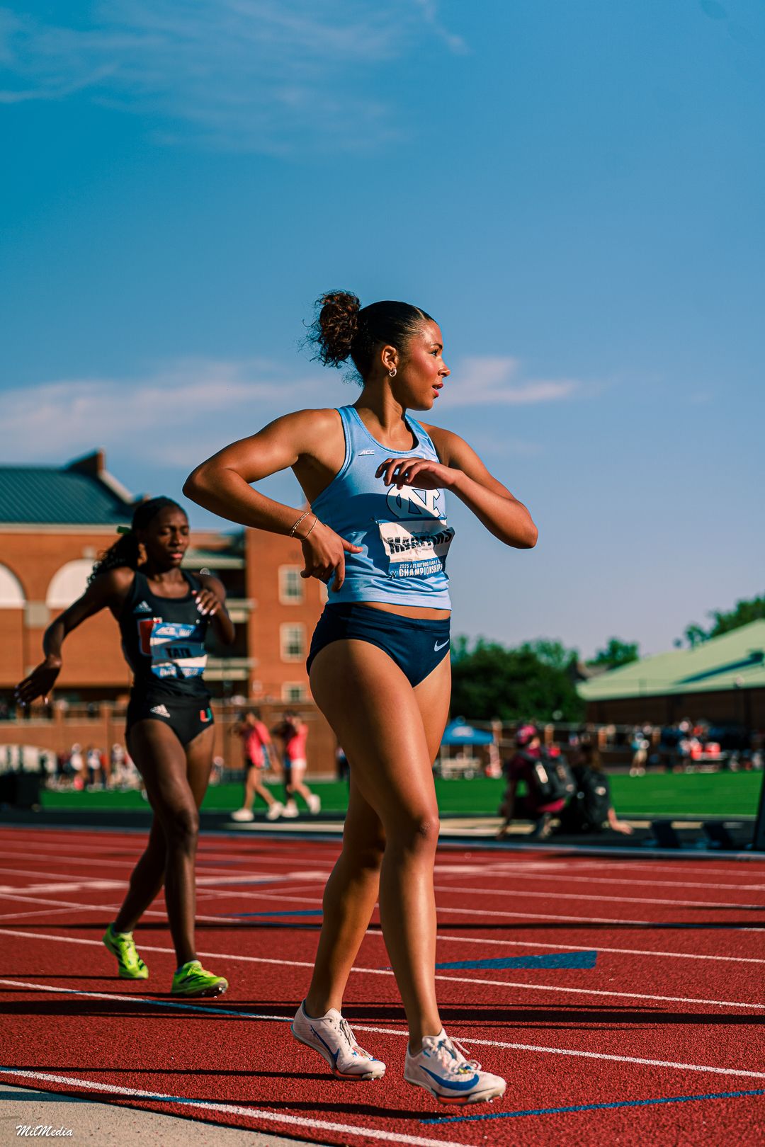 Athletes in starting position on a red running track during a sunny day competition during the ACC Track and Field Championships.