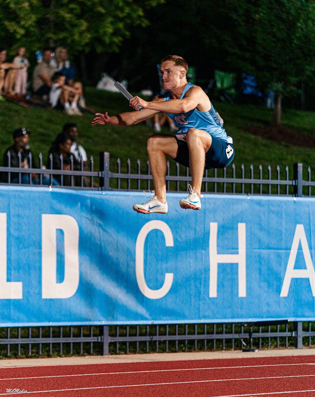 Athlete jumps over field championship banner during the ACC Outdoor Track and Field Championships.