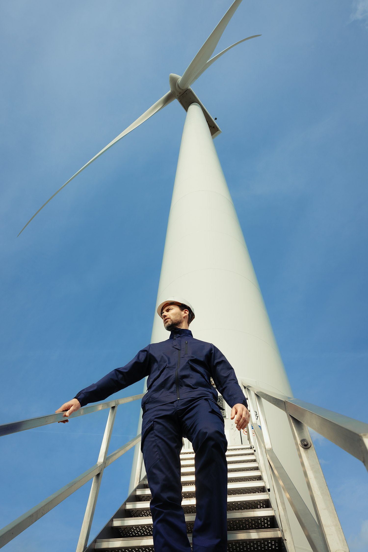 Homme en tenue de chantier Molinel qui descend les escaliers d’une éolienne