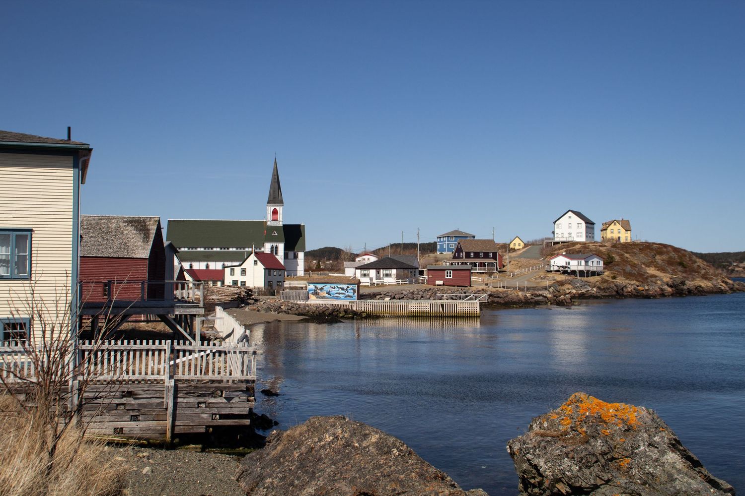 Maisons colorées et église de Trinity en bord de mer.