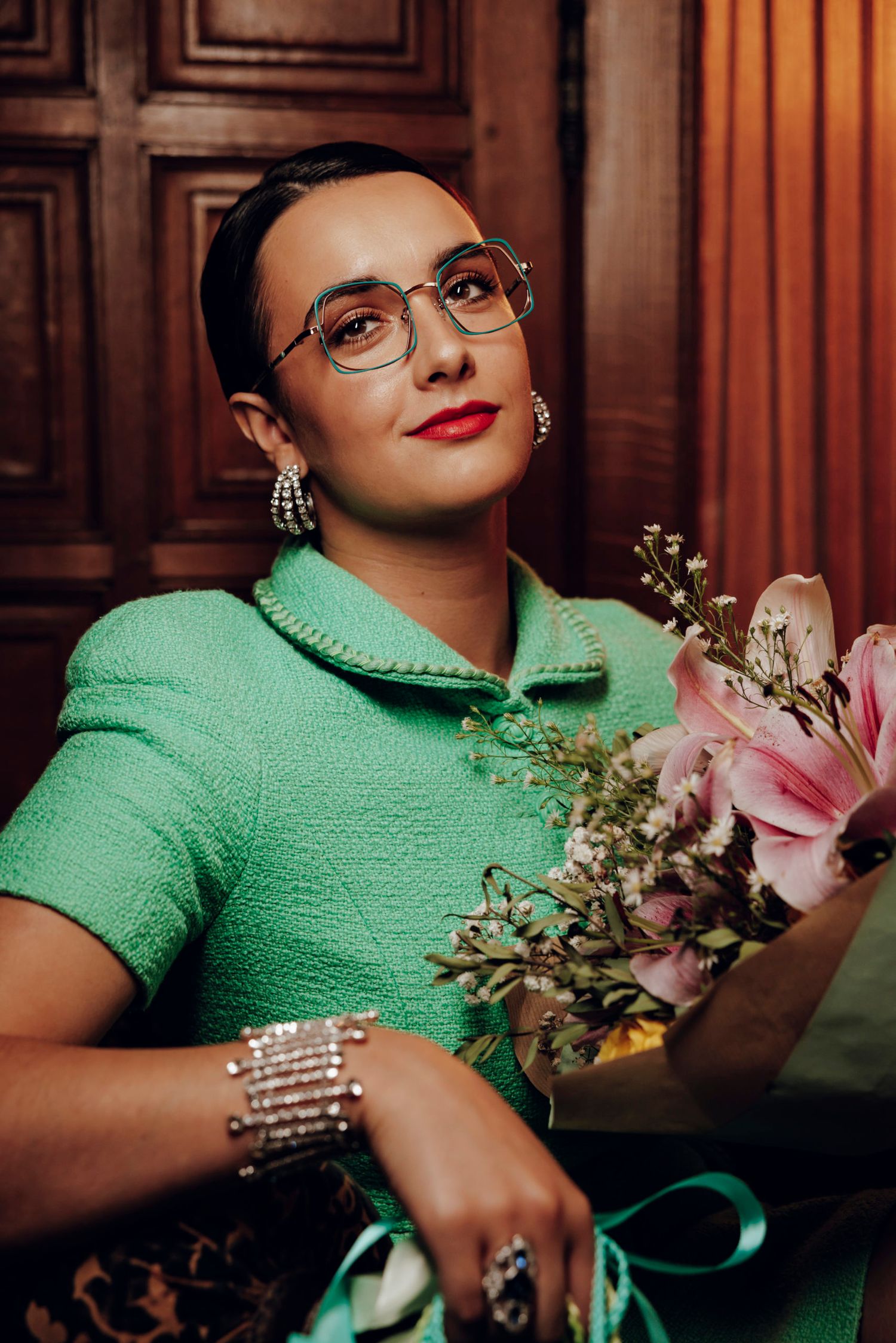 Portrait d’une femme souriante avec des lunettes et un bouquet de fleurs