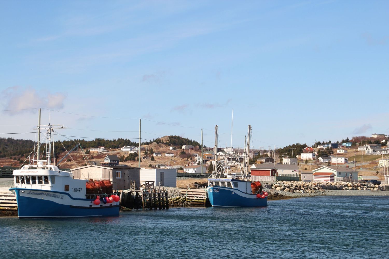 Port de Terres Neuves avec cabanes de pêcheurs et bateaux bleus et blancs