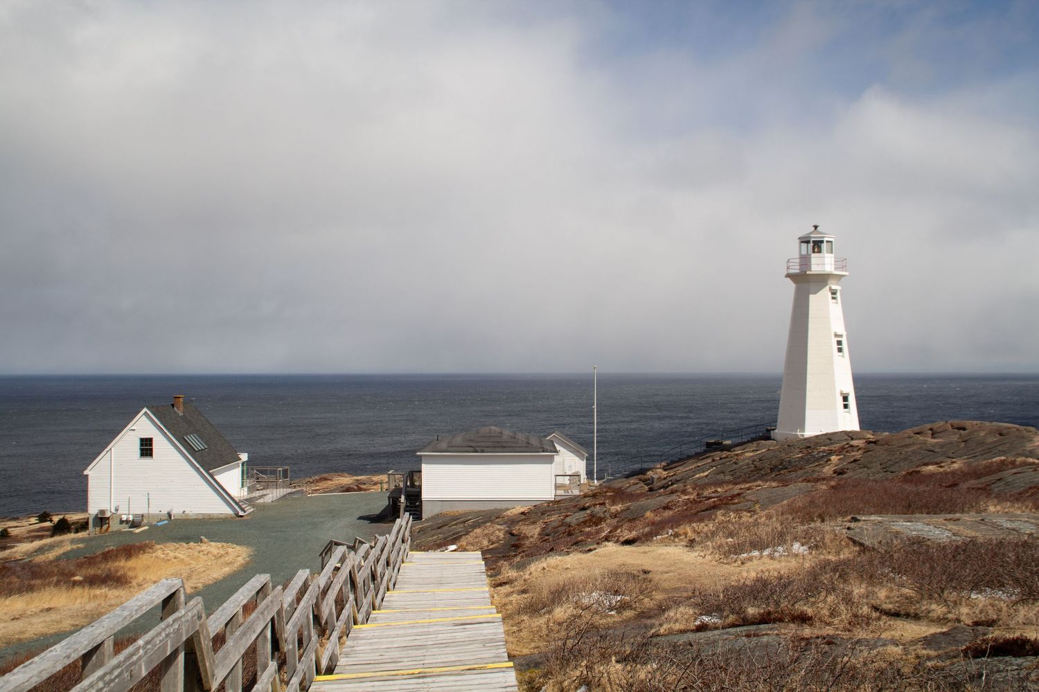 Phare et maisons du site historique du Cape Spear à Terre-Neuve avec vue sur la mer.