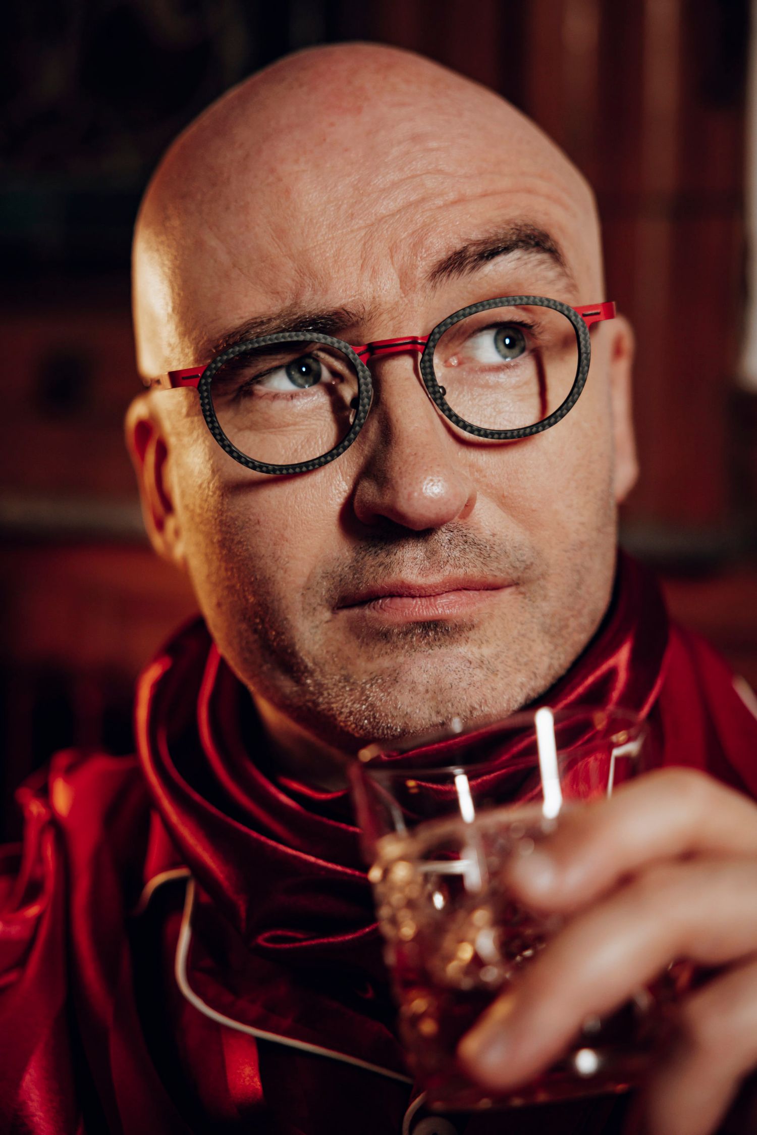 Hommes habillé à la mode des années folles, portant des lunettes et haussant un sourcil avec un verre de whisky