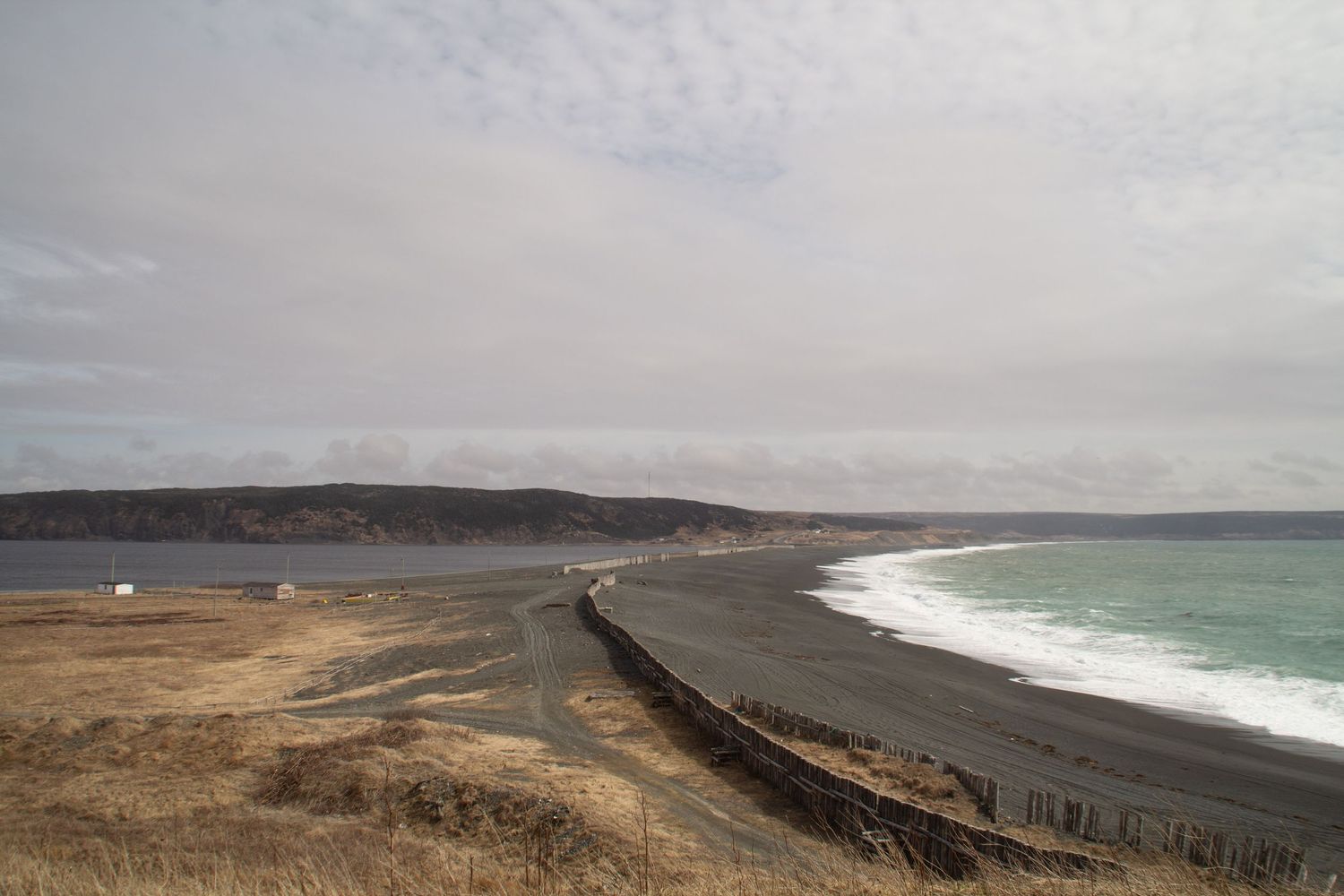 Vue sur la plage de St Vincent à Terre-Neuve séparé d’un lac par une route.