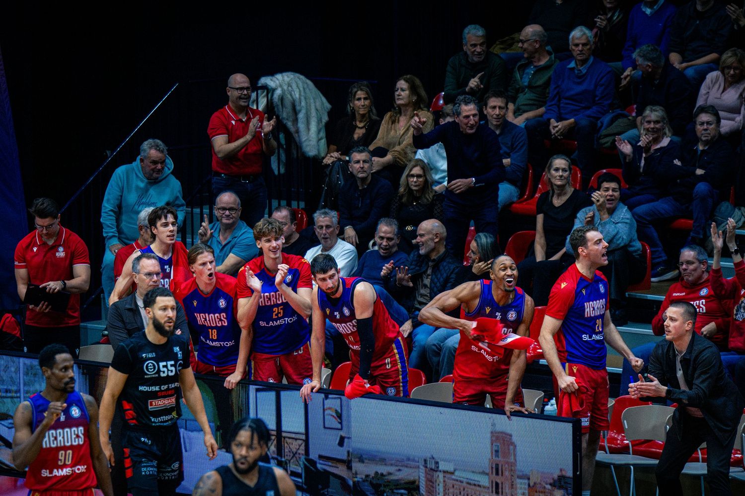 De spelersbank van de Heroes Den Bosch juicht na een 3 punter