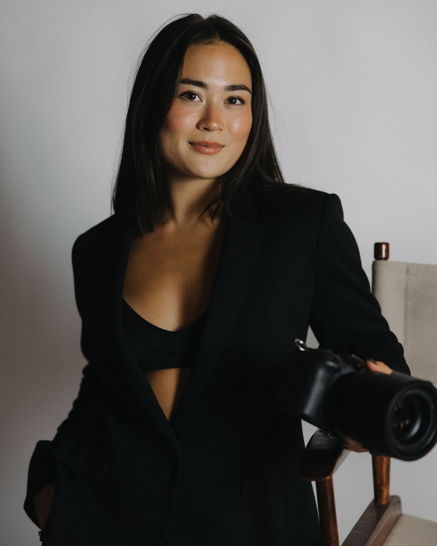 Professional photography setup with wooden chair and camera equipment in studio setting.