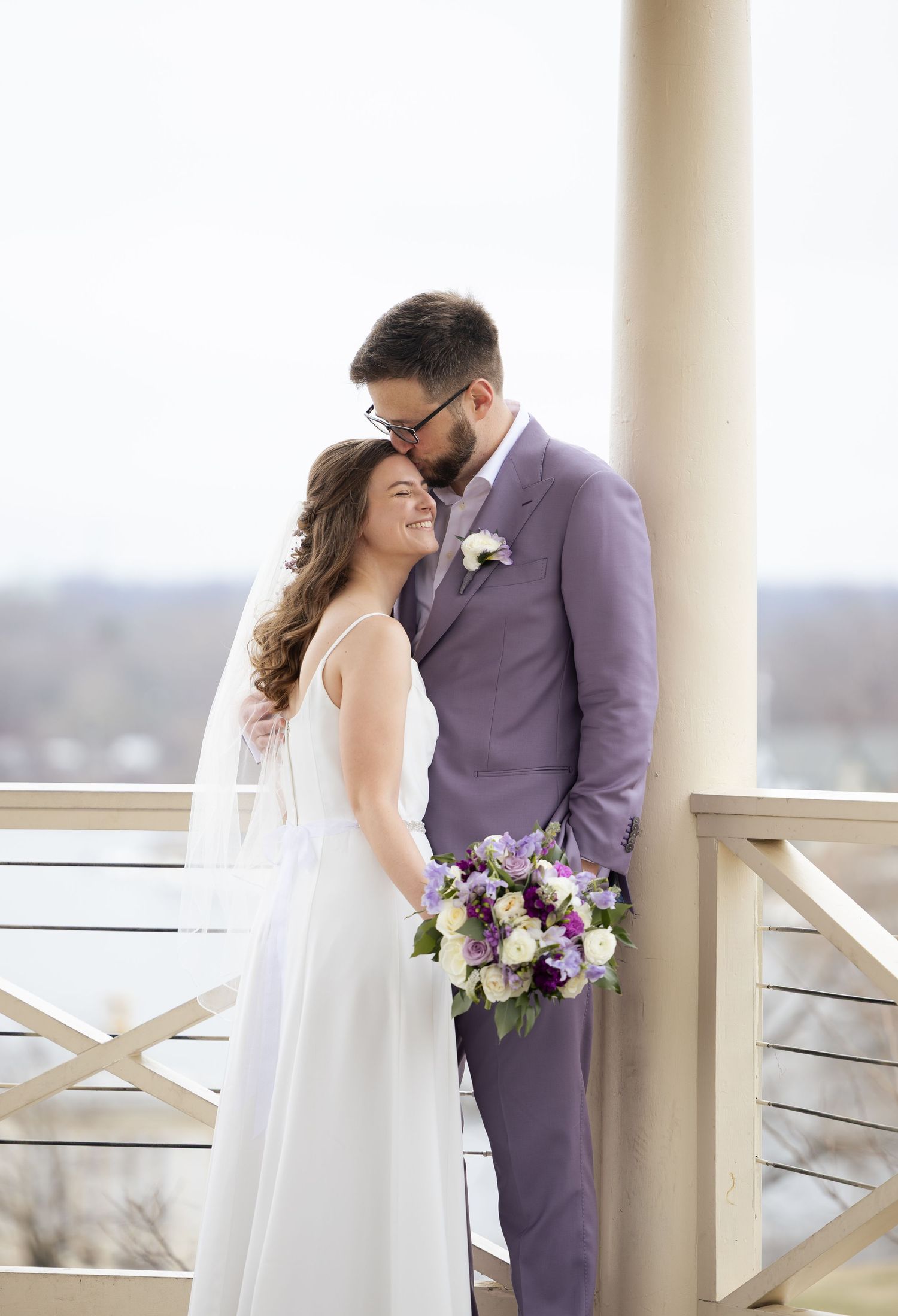 Intimate wedding moment captured after the first look with purple and white florals.
