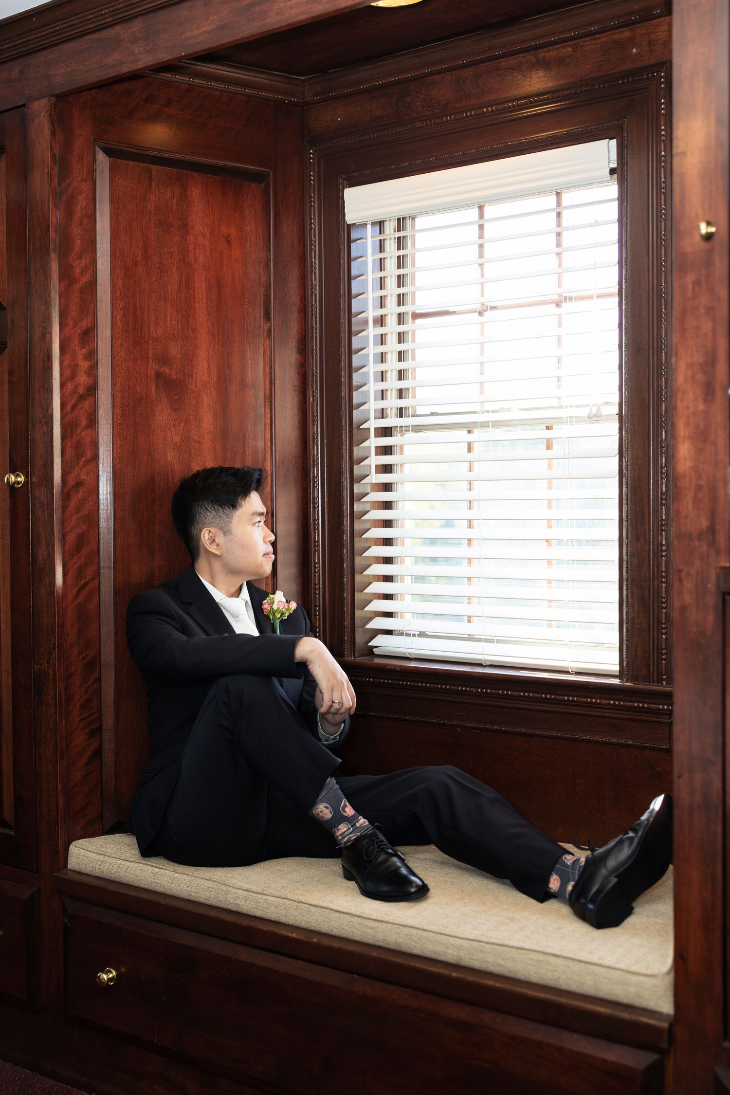 Interior shots of a groom lounging on a cushioned window bench.