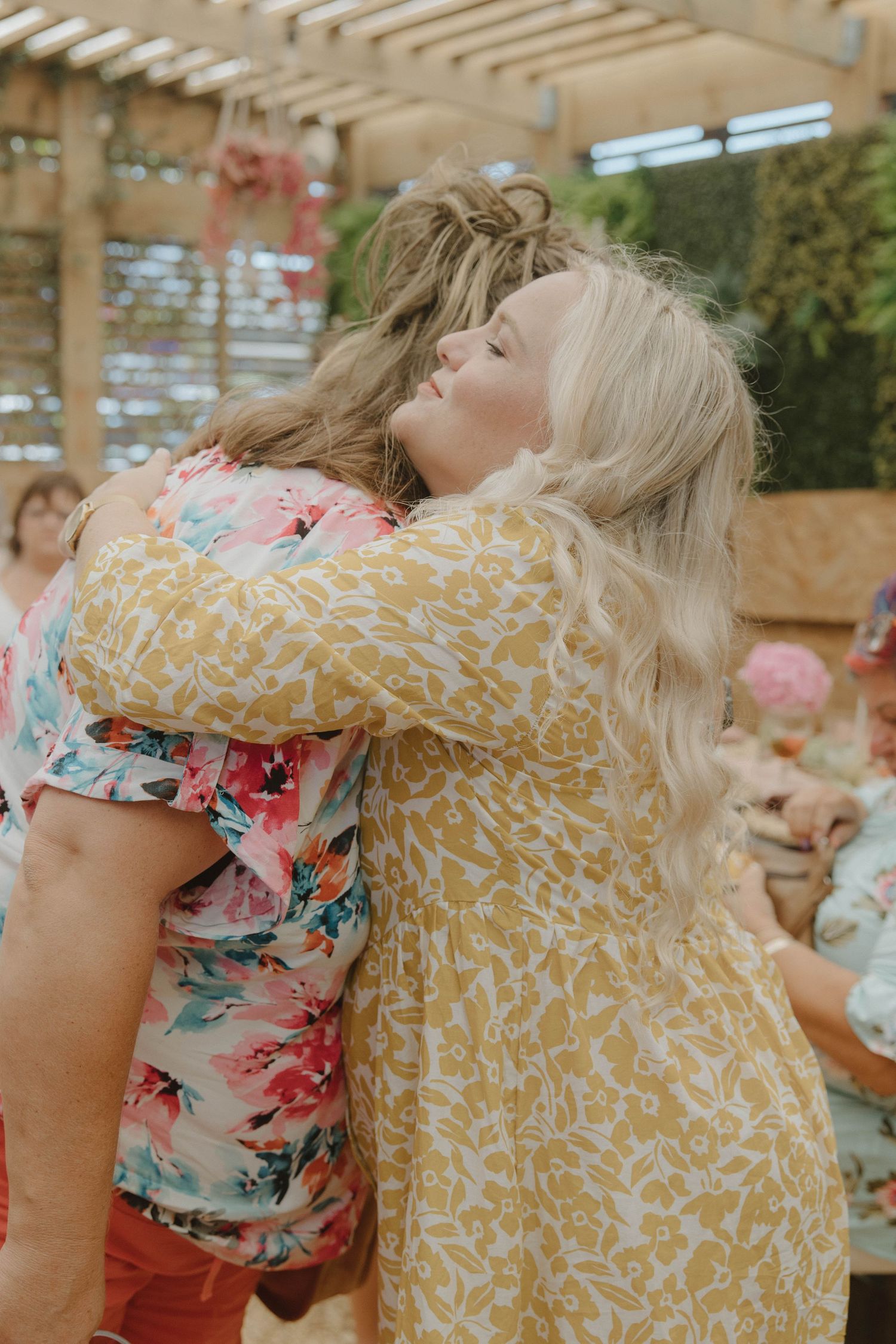 Emotional hug between mom-to-be and friend at baby shower