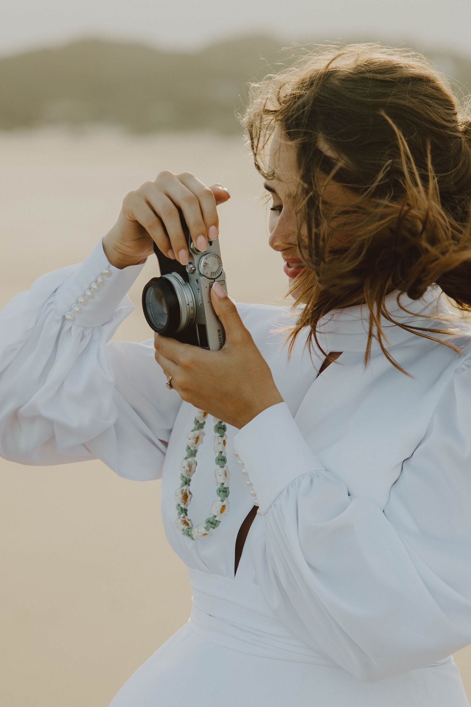 Candid photo of bride on beach taking photo