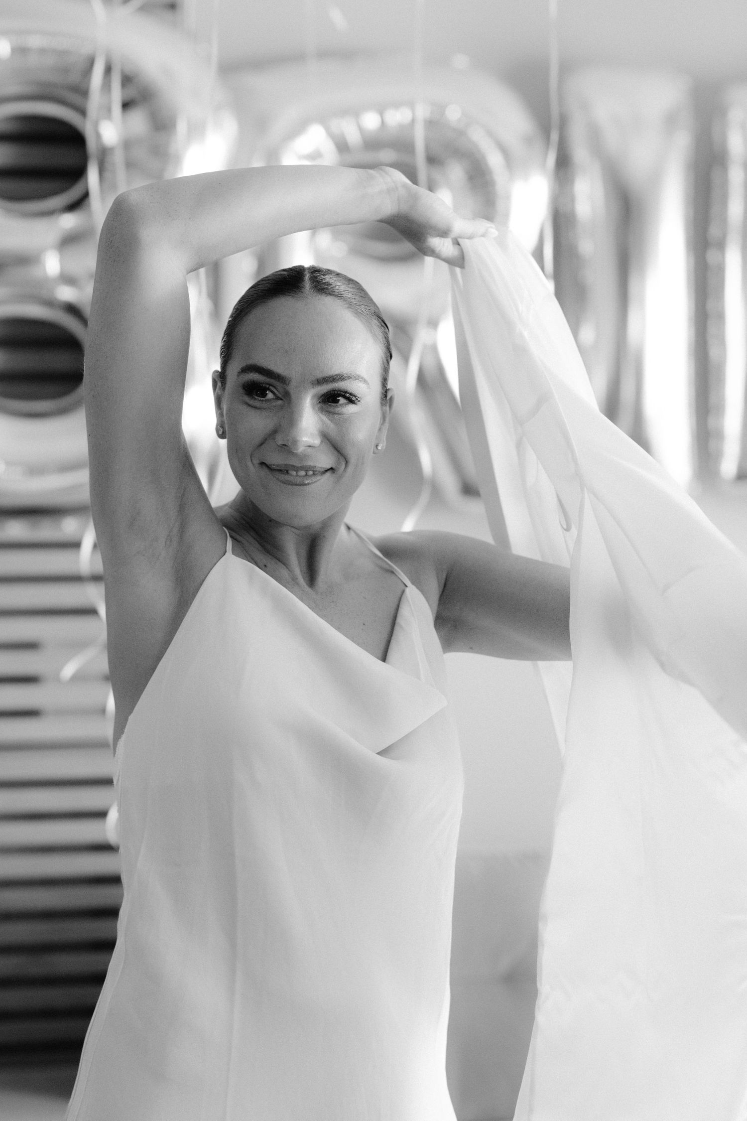 A series of black and white photographs showing a figure in flowing white fabric creating graceful movement and poses.