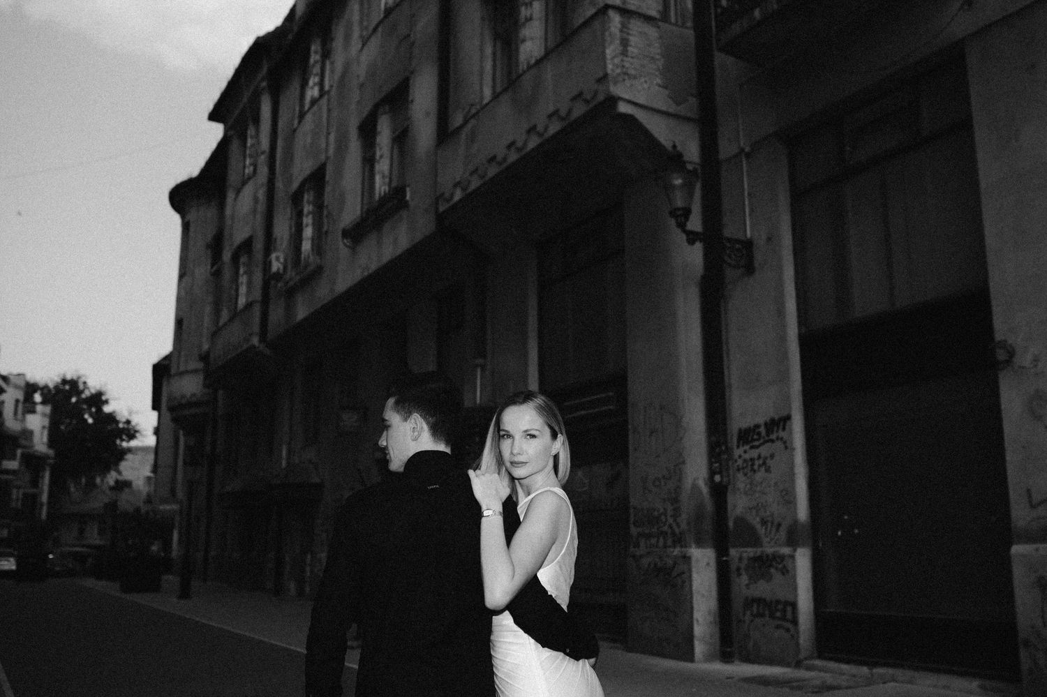 Artistic black and white wedding portraits taken in urban alleyway.
