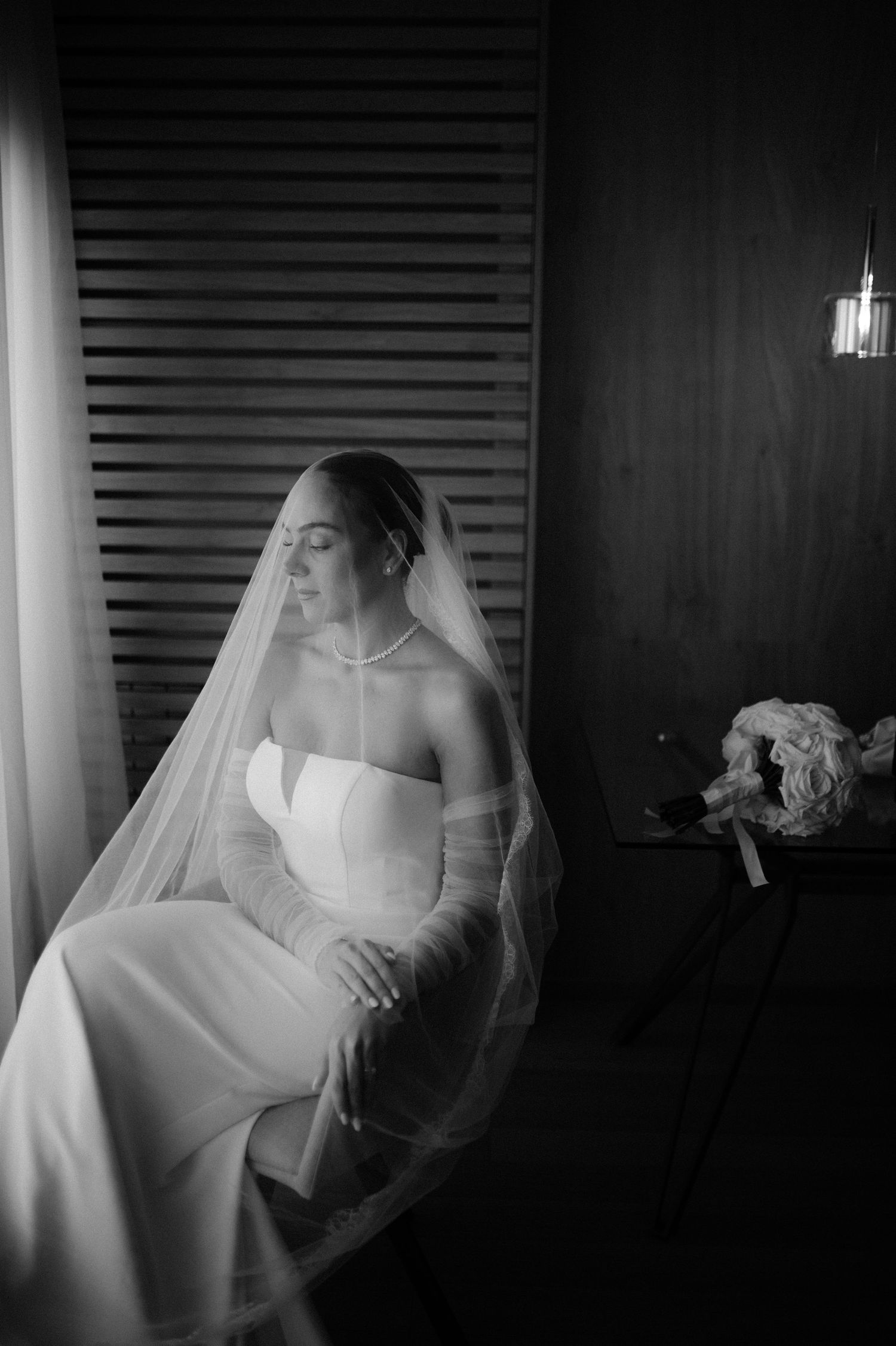 A dramatic black and white photo series shows a bride in a white veil and dress posing against a dark background.