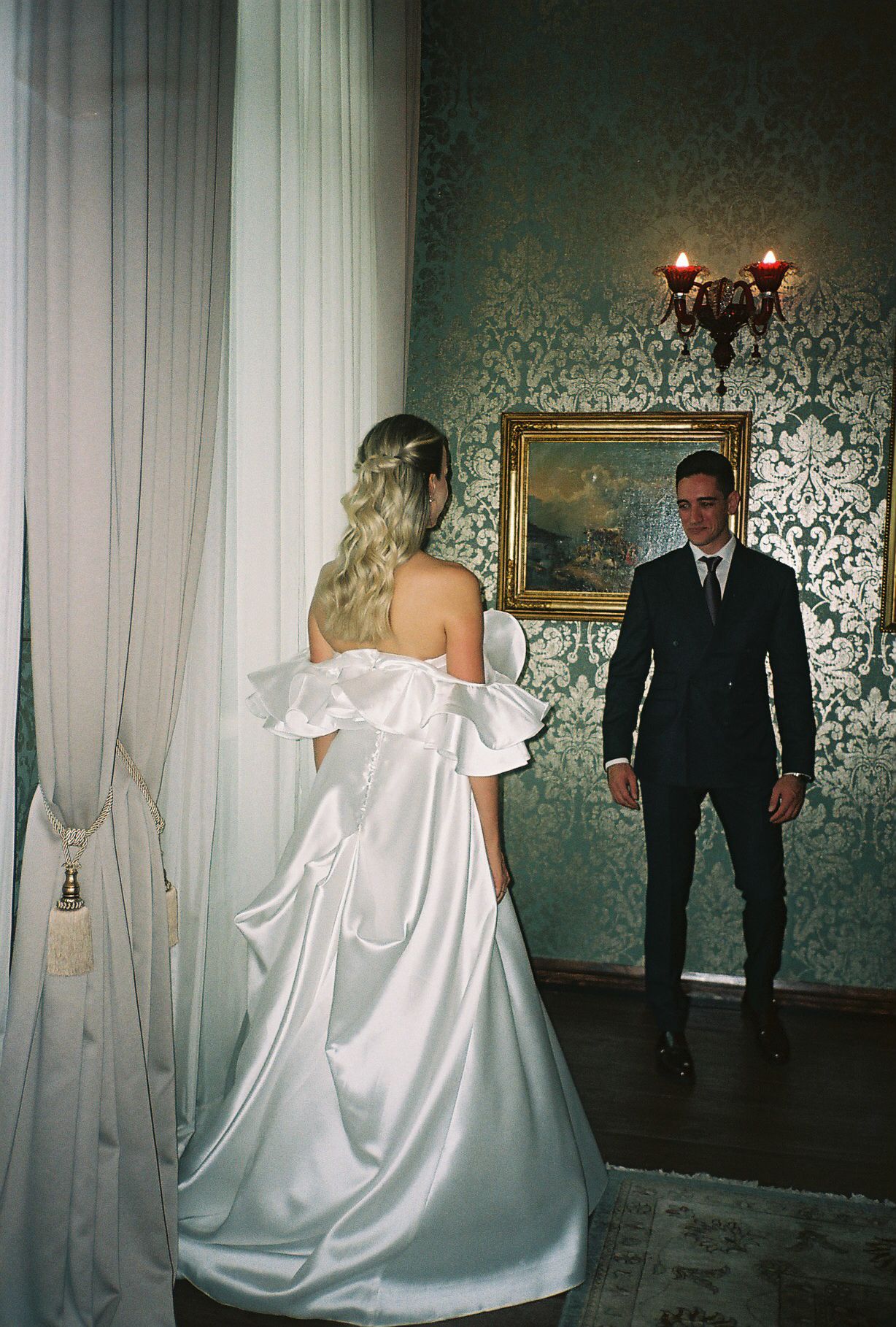 A romantic wedding portrait series with a couple in a vintage-style room featuring green wallpaper and ornate gold frames.