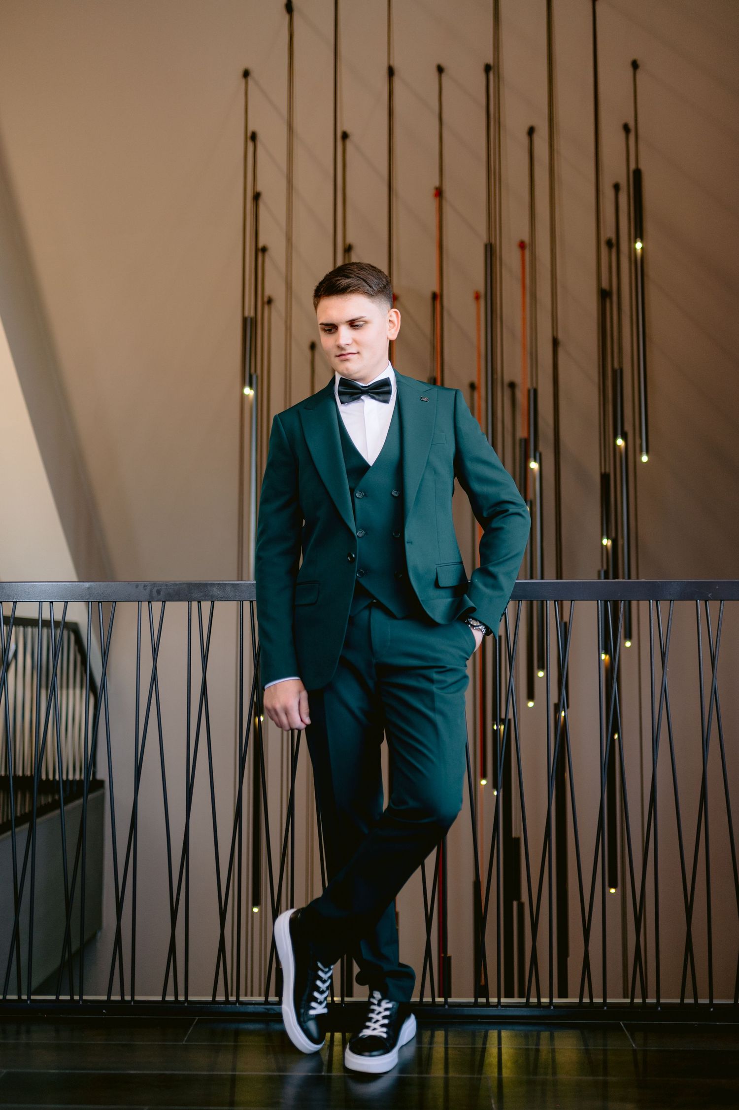 Maturant u zelenom trodelnom odelu i patikama u modernom enterijeru u Banjoj Luci, fotografisanje matura u editorial stilu