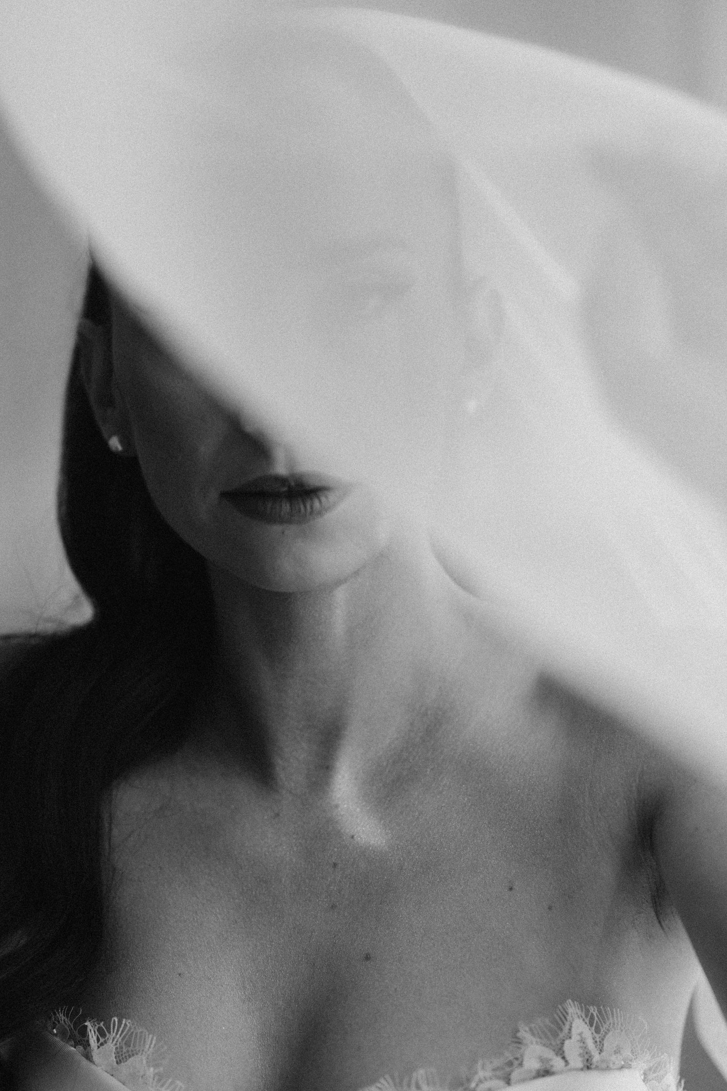 Ethereal black and white portrait through sheer fabric.