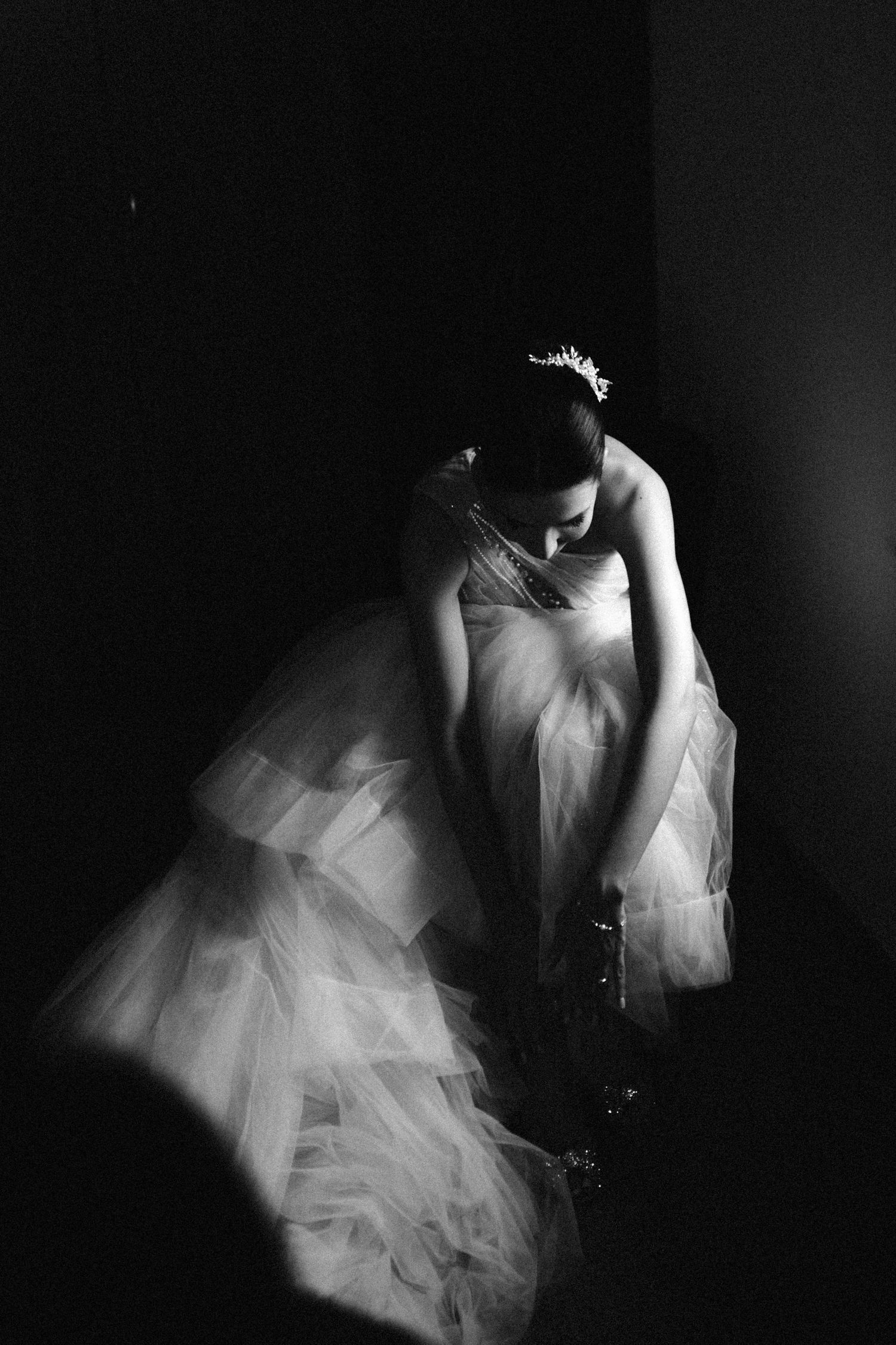 Dramatic black and white photo of a flowing tulle wedding dress in motion.