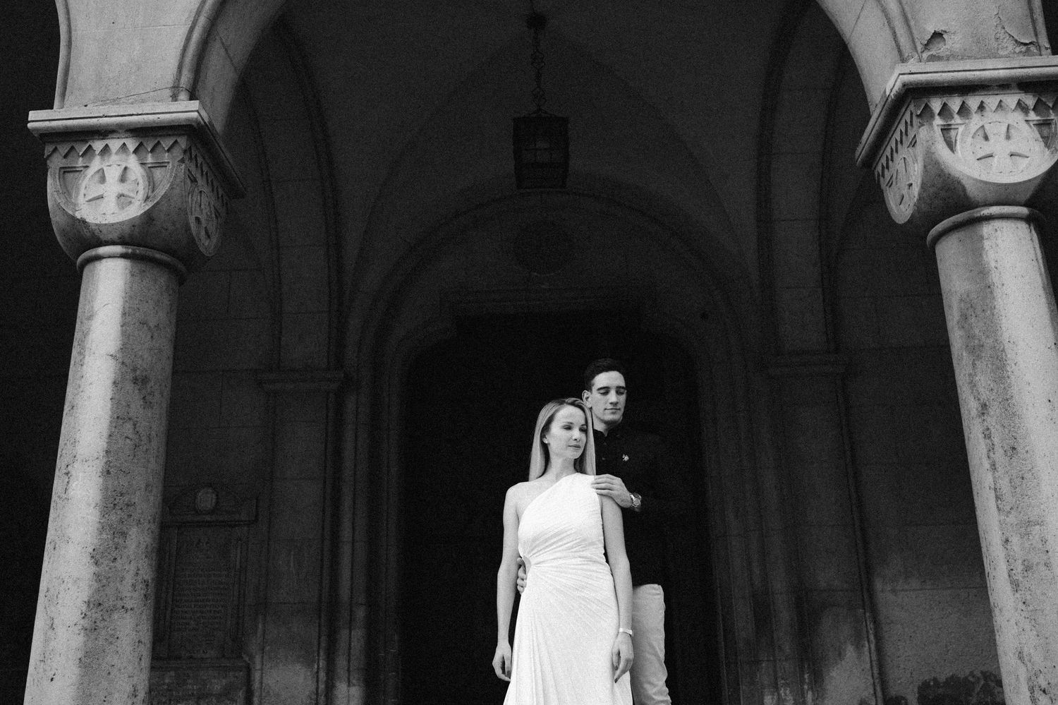 Elegant wedding ceremony in a historic stone church with arched columns and natural light streaming in.