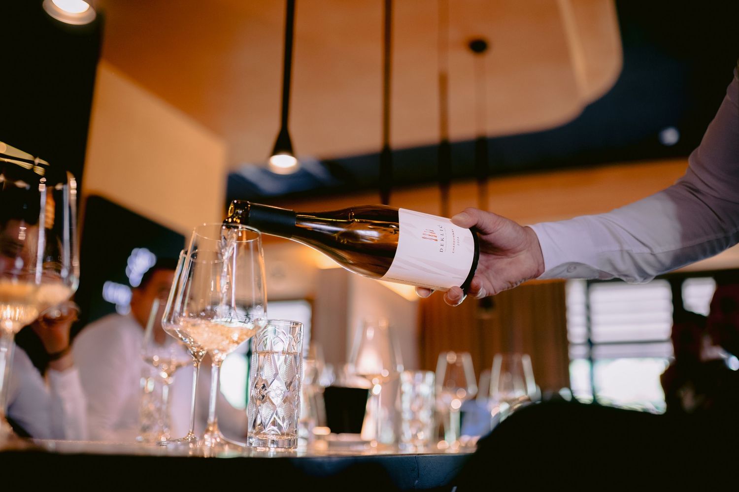 Wine glasses lined up at an elegant bar or restaurant counter.