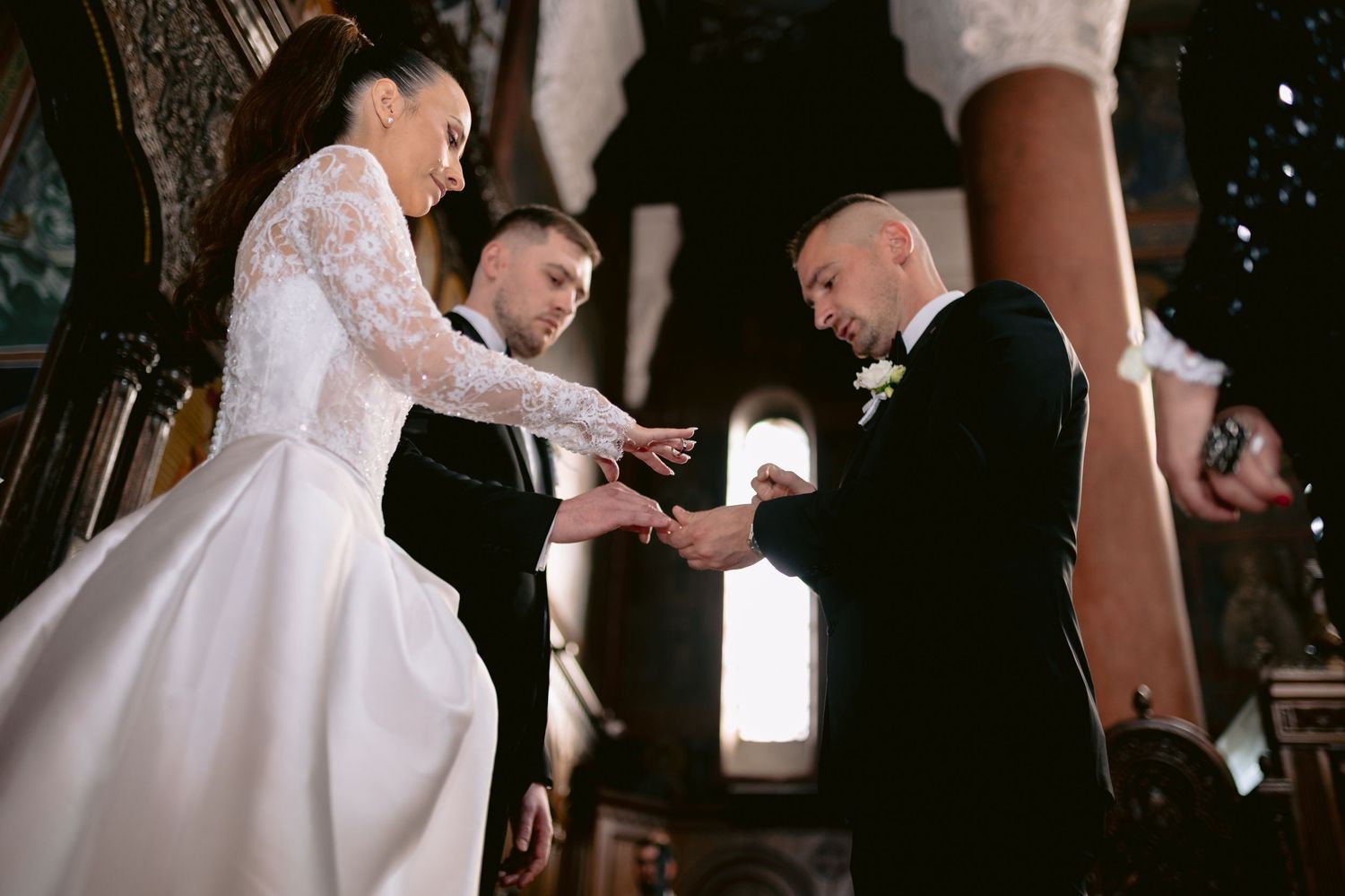 A bride and groom share their first dance at a wedding reception while guests watch and take photos.
