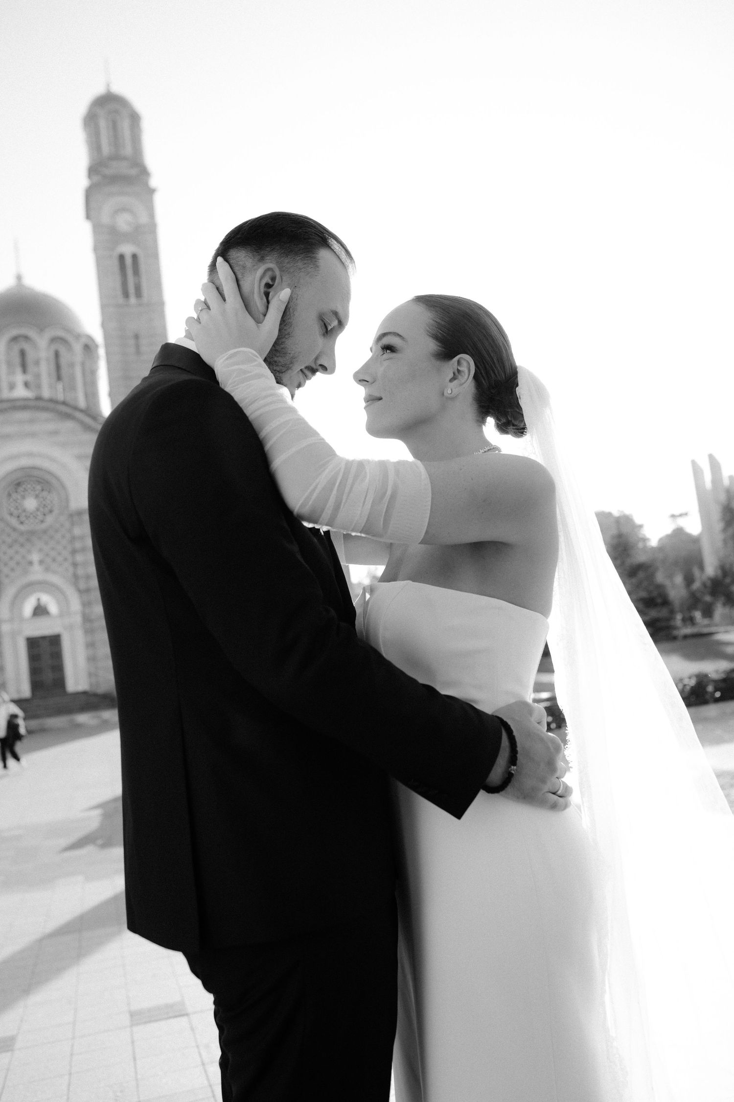 Black and white wedding photos show couple dancing together with church steeples in background.