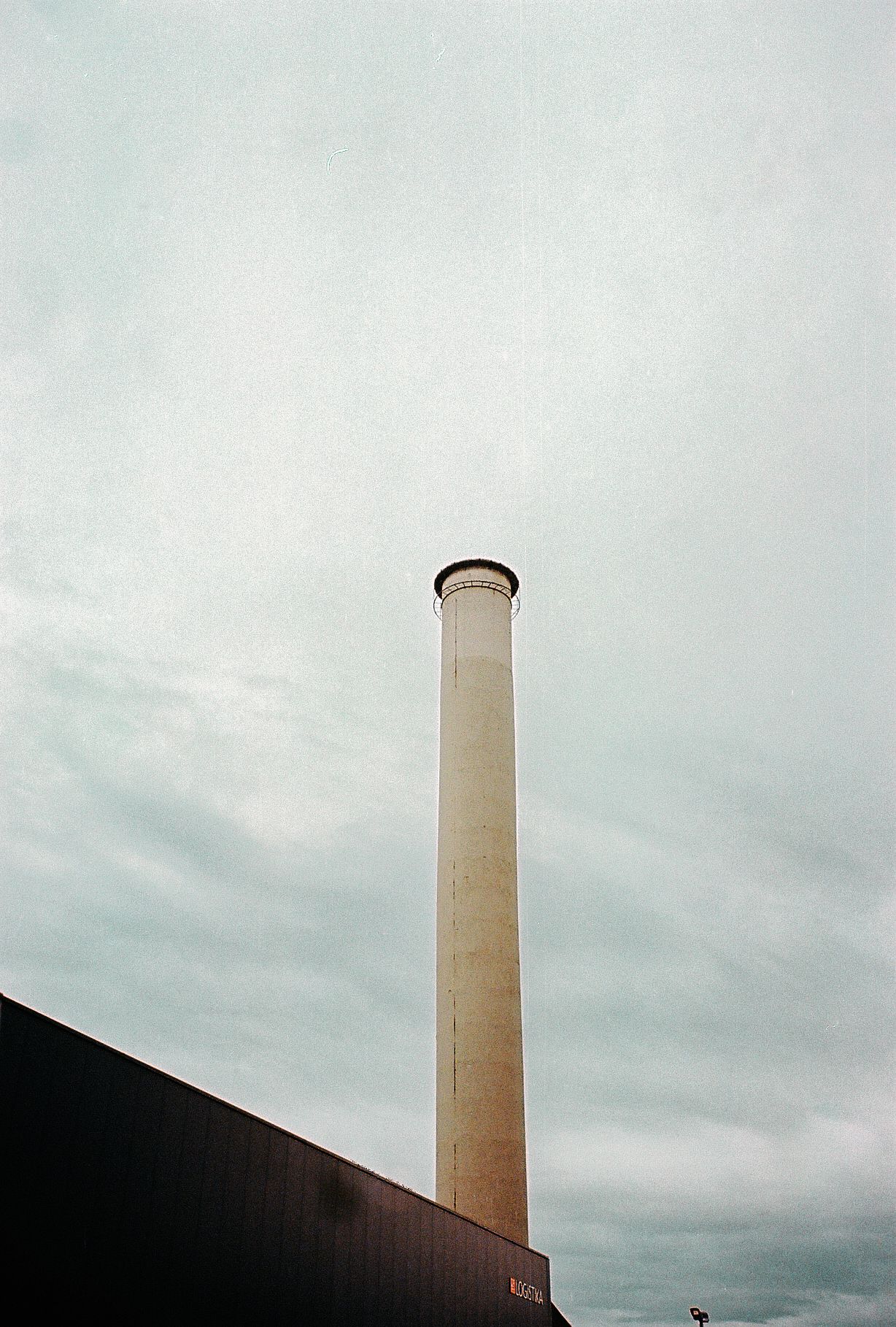 Tall industrial smokestack photographed from different angles against an overcast sky.