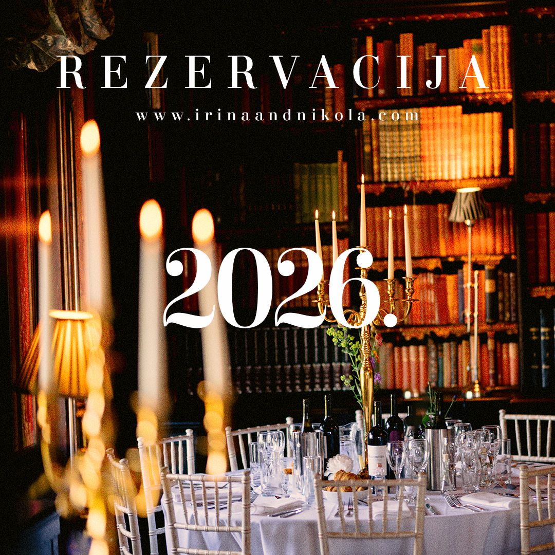 Elegant dining table set for wedding event with glowing candles and crystal glassware in romantic lighting.