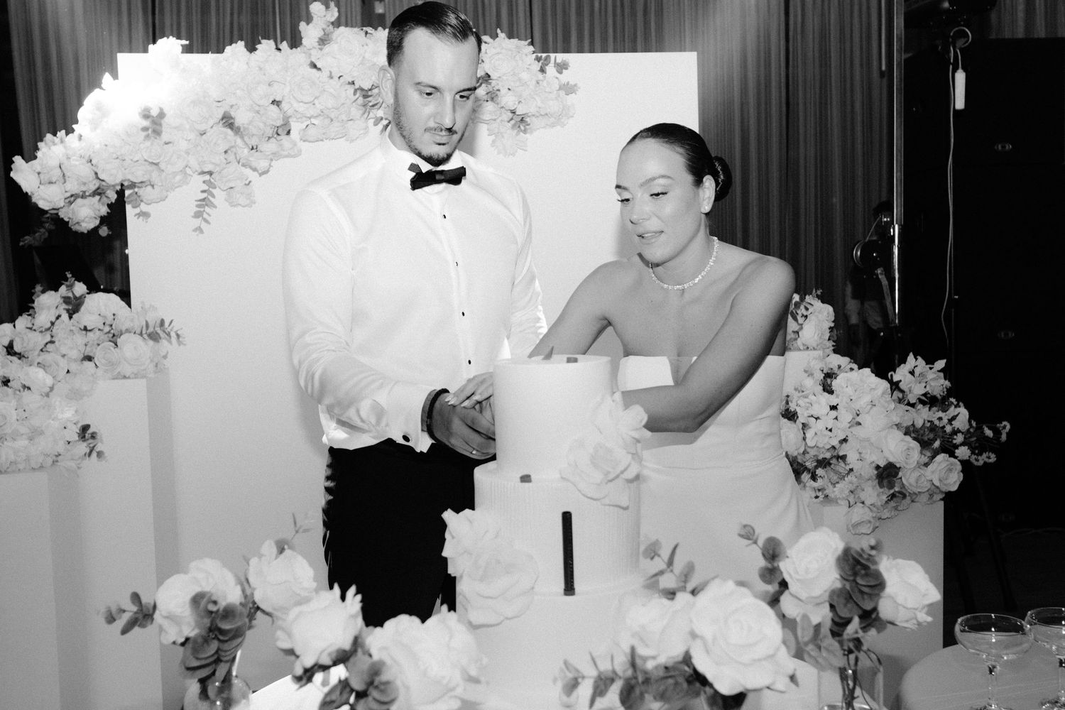 A series of black and white wedding photos showing floral arrangements and reception decor.