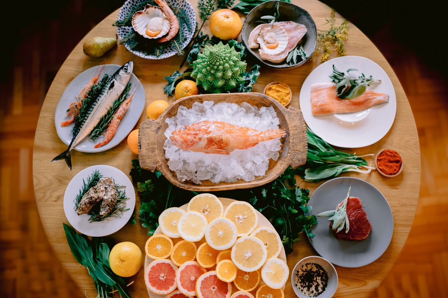 Fresh seafood platter with citrus fruits and garnishes arranged on rustic wooden table for elegant dining.